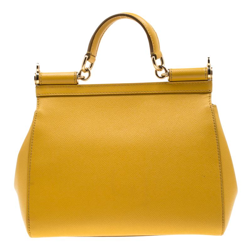 This gorgeous yellow Miss Sicily bag from Dolce and Gabbana is a handbag coveted by women around the world. It has a well-structured design and a flap that opens to a compartment with fabric lining and enough space to fit your essentials. The bag
