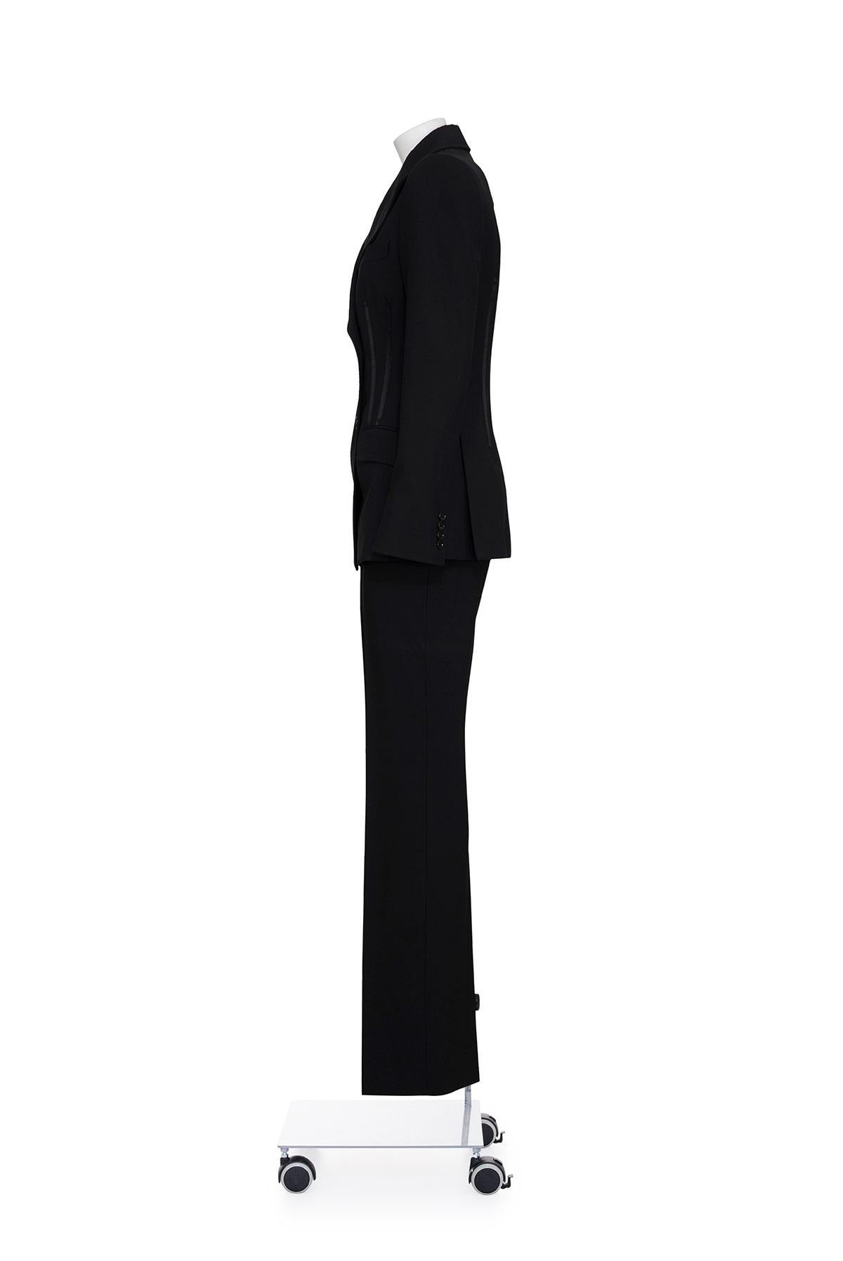 00's iconic suit with bustier effect double breast jacket by Dolce & Gabbana.
Satin details at waist.
Two flap pockets.
Fully lined with animalier fabric.
Straight trousers with side pockets.
The composition is 97% virgin wool and 3% elastane.
The