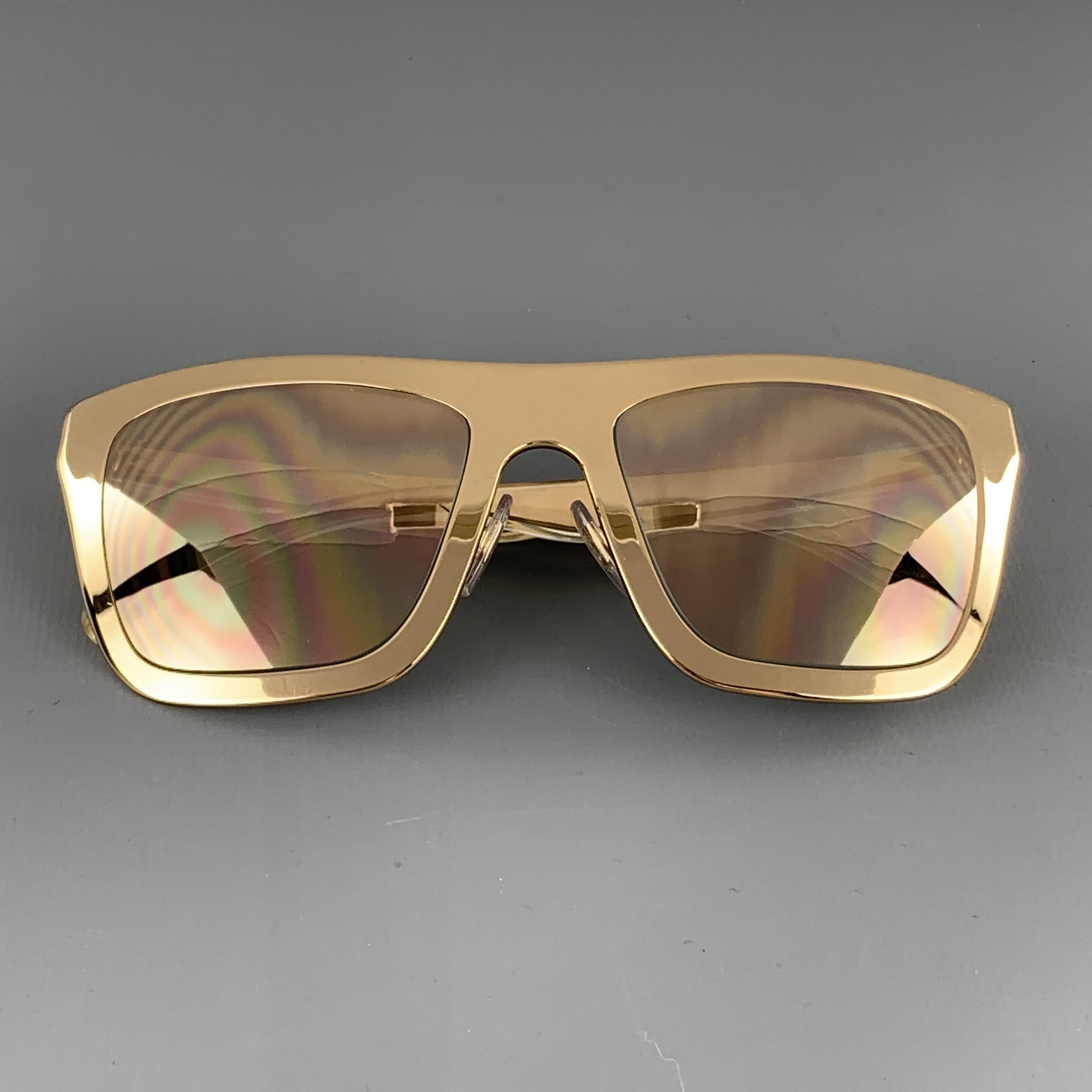 DOLCE & GABBANA sunglasses come in 18 karat gold plated polished metal in an oversized wayfarer shape with mirrored lenses and clear acrylic encased metal arms. Includes case. Made in Italy.

Very Good Pre-Owned Condition.
Marked: GOLD PLATED