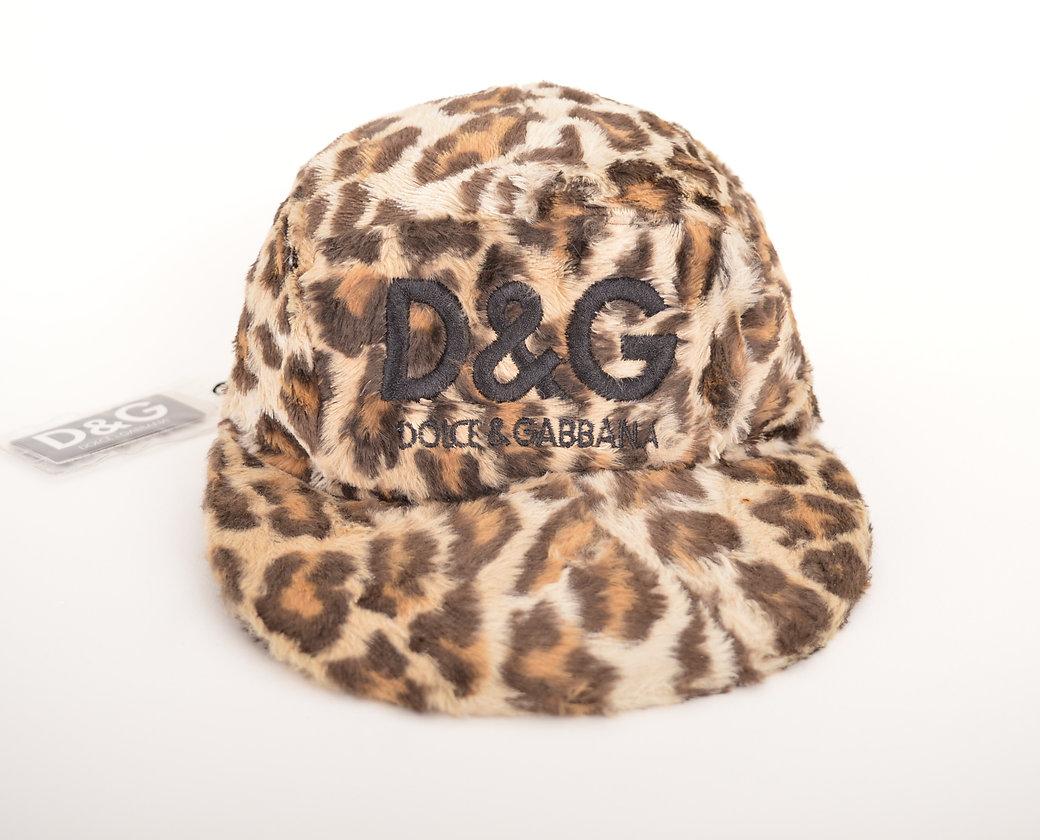 A 1990's faux fur, five panel cap by DOLCE & GABBANA. In leopard print fabric with large D&G embroided spellout on the front. 
 
Features;
Fully lined interior
Elastic rear panel
Original tags attatched
62% Cotton / 38% Viscose
MADE IN ITALY
