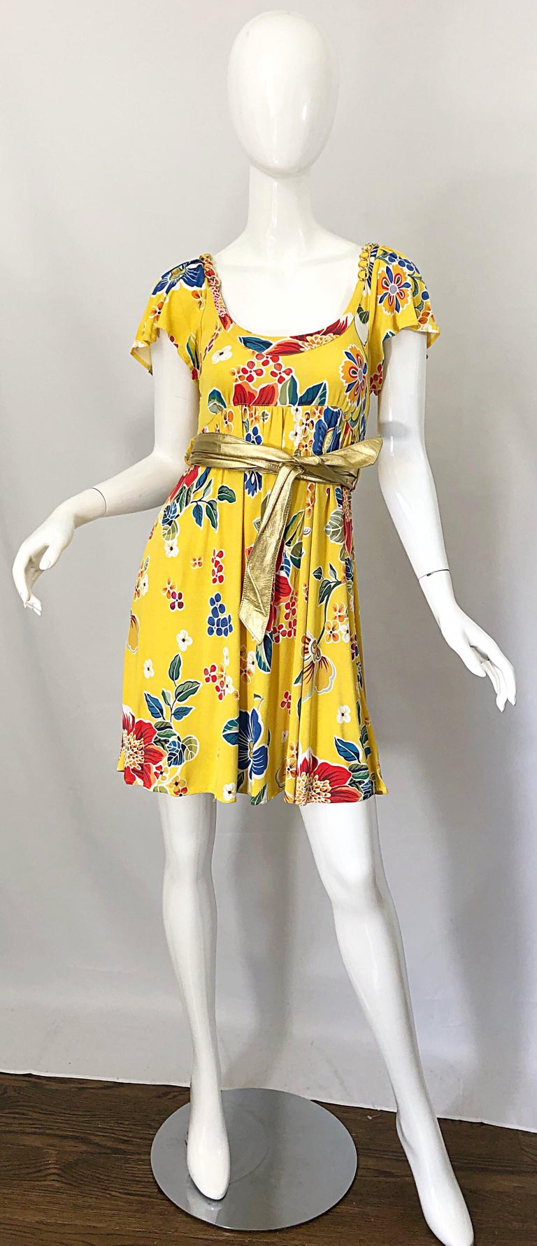 Sweet late 1990s DOLCE & GABBANA yellow rayon jersey chainlink belted vintage babydoll dress! Features a vibrant yellow, with flowers in red, green, blue and white. Gold metal chainlinks around the neckline. Original detachable gold metallic leather