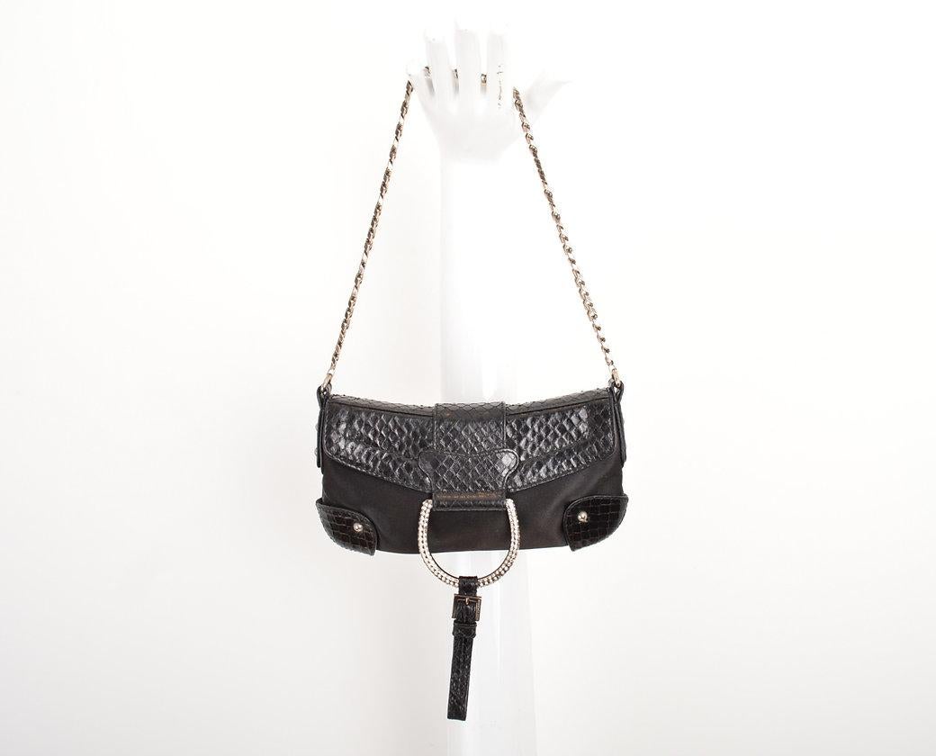 Un petit sac à bandoulière des années 2000 en python noir, satin et cristaux Swarovski par DOLCE & GABANNA. 
 
Caractéristiques ;
Fixation par boutons-pression
Bandoulière en chaîne métallique
Compartiment intérieur pour cartes
Matériel en métal