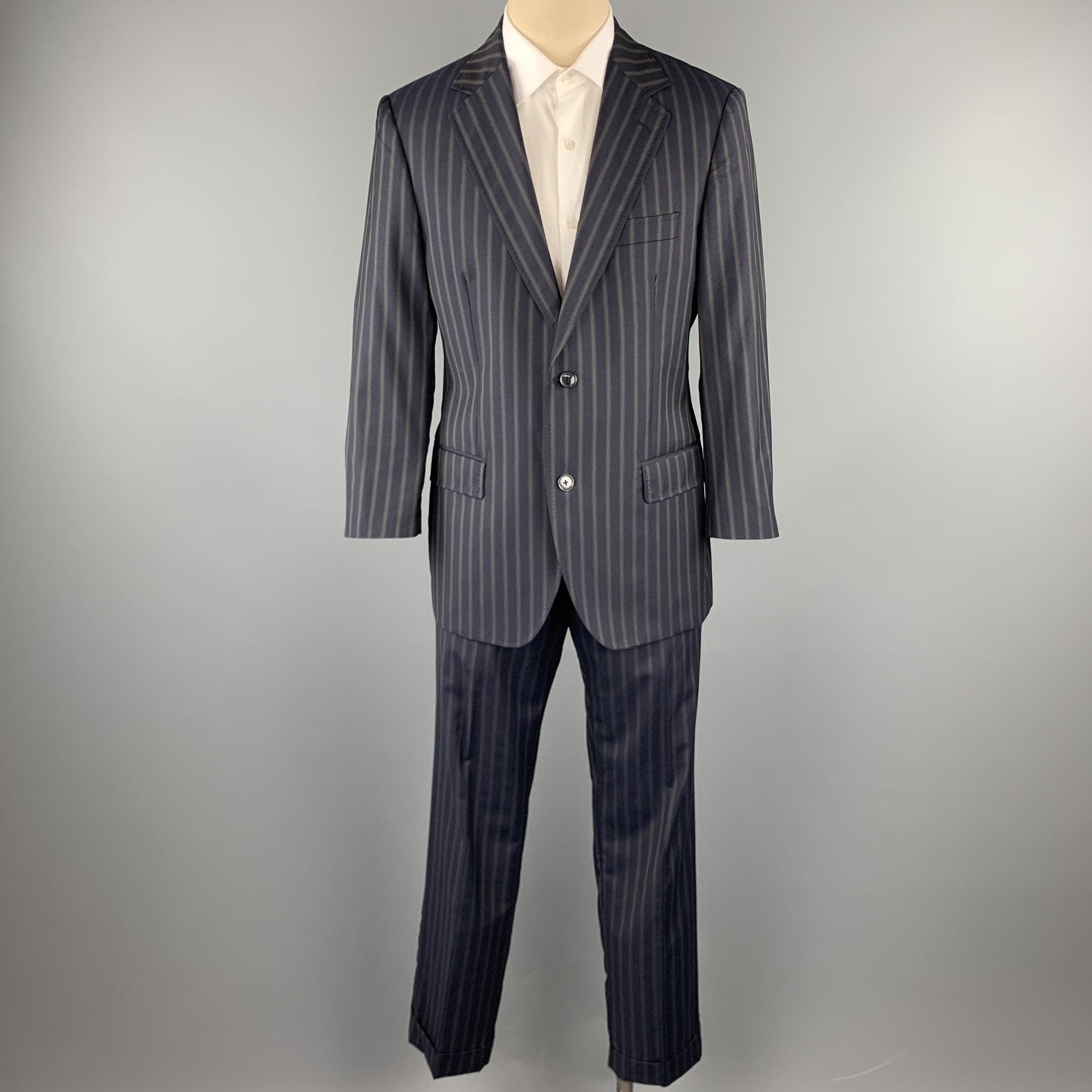 DOLCE & GABBANA suit comes in a navy stripe wool with a monogram liner and includes a single breasted, two button sport coat with a notch lapel and matching
 pleated cuff front trousers. 
Made in Italy.Excellent Pre-Owned Condition. 

Marked:   IT