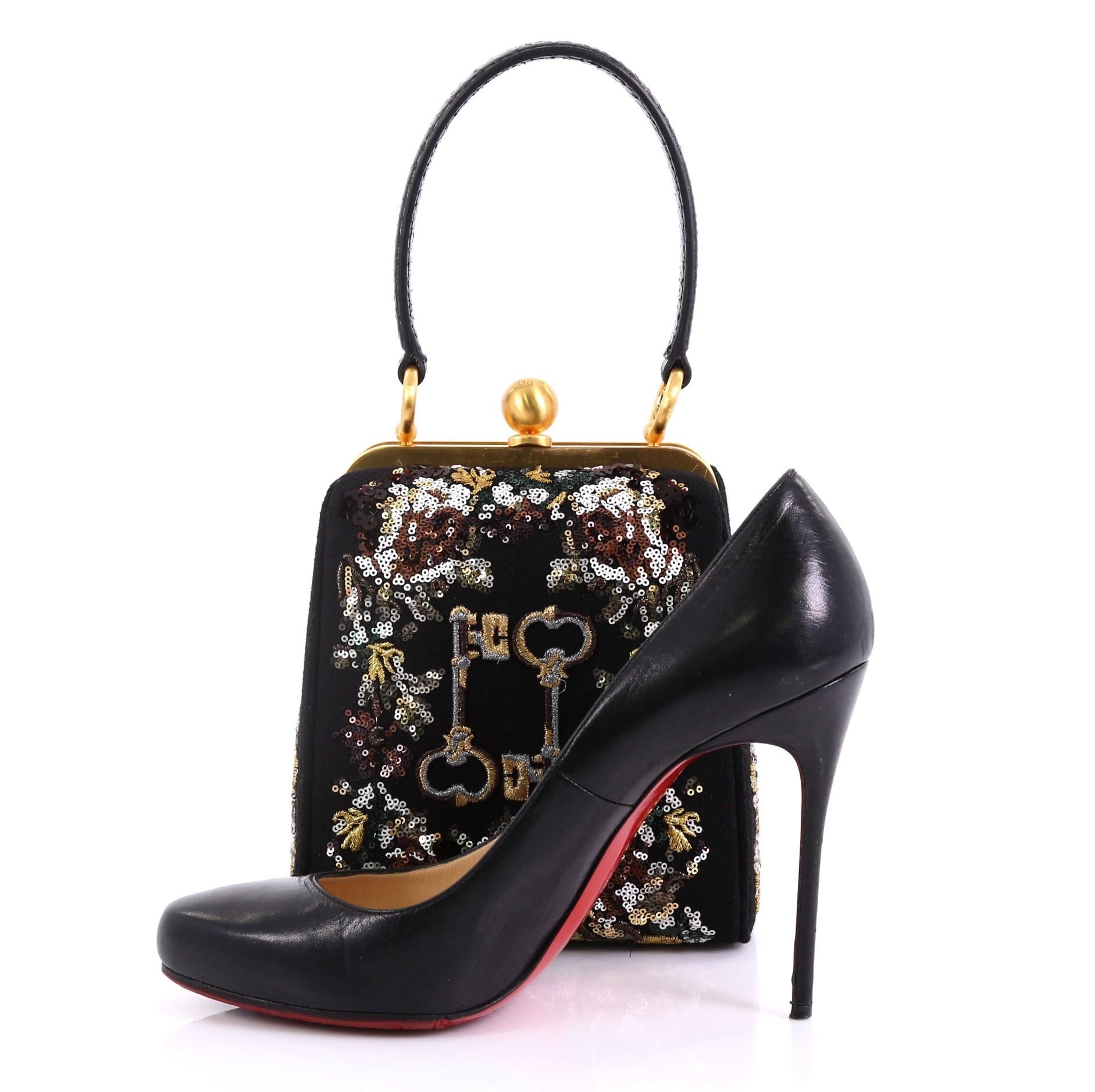 This Dolce & Gabbana Agata Handbag Embroidered Fabric with Sequins Small, crafted from black embroidered fabric with sequins, features leather top handle and gold-tone hardware. Its clasp closure opens to a black fabric interior with side slip