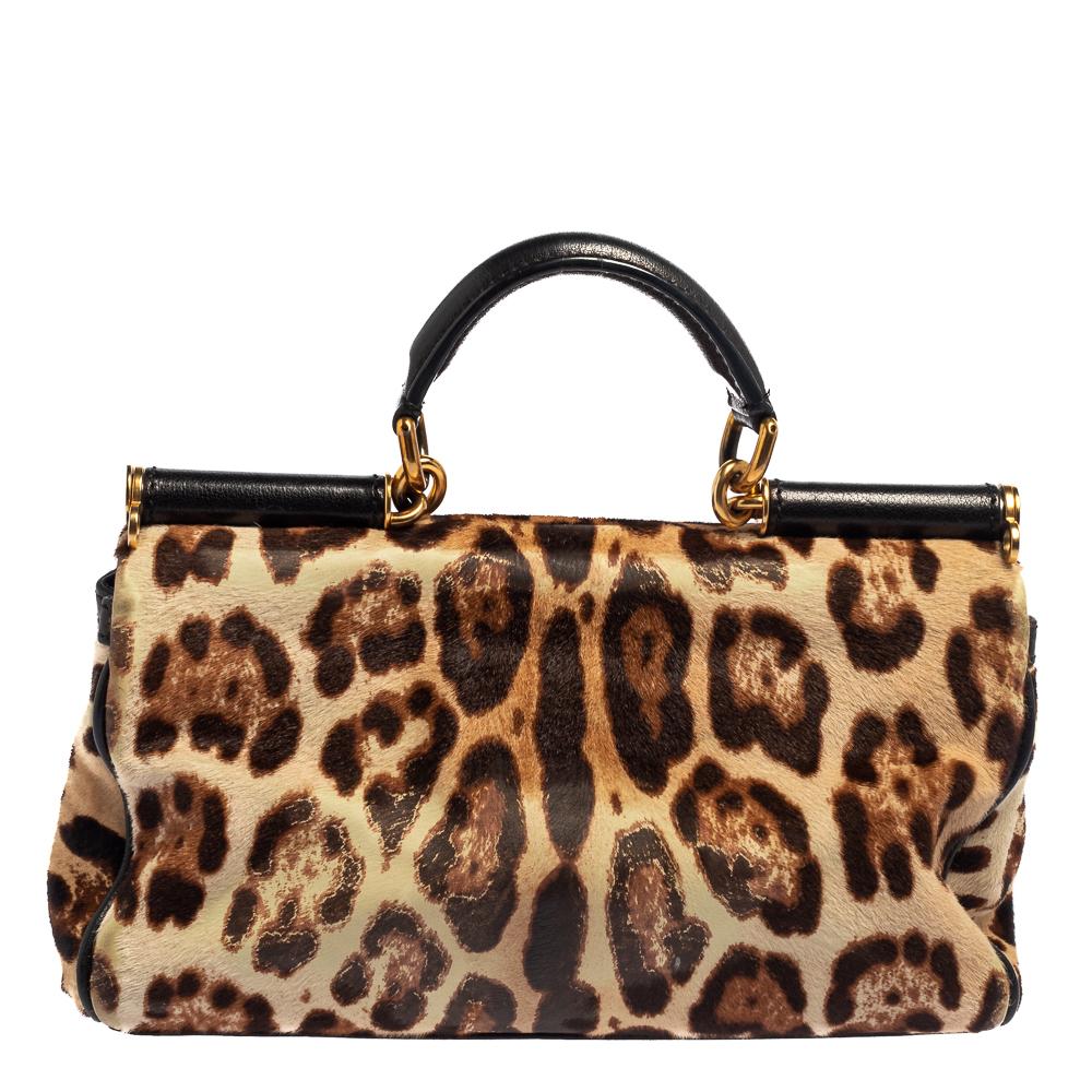 This uniquely designed Miss Sicily bag by Dolce & Gabbana has been made from leopard-printed calf hair. With a structured top, it features a single top handle and a detachable shoulder strap. The top magnetic stud closure opens to a suede and satin