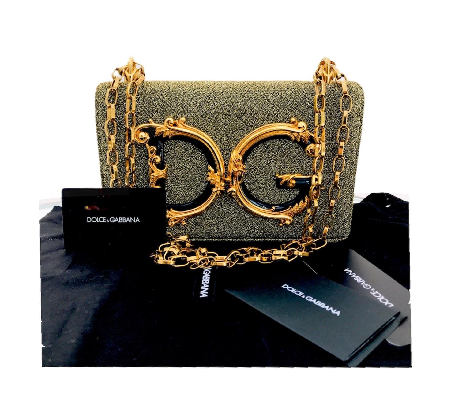 This metallic Dolce & Gabbana baroque logo detail shoulder bag is sumptuously sculpted in Italy from 100% Nappa leather in a shoulder bag design. It features a thick gold-tone chain shoulder strap, a flap front closure with magnetic clasp fastening,