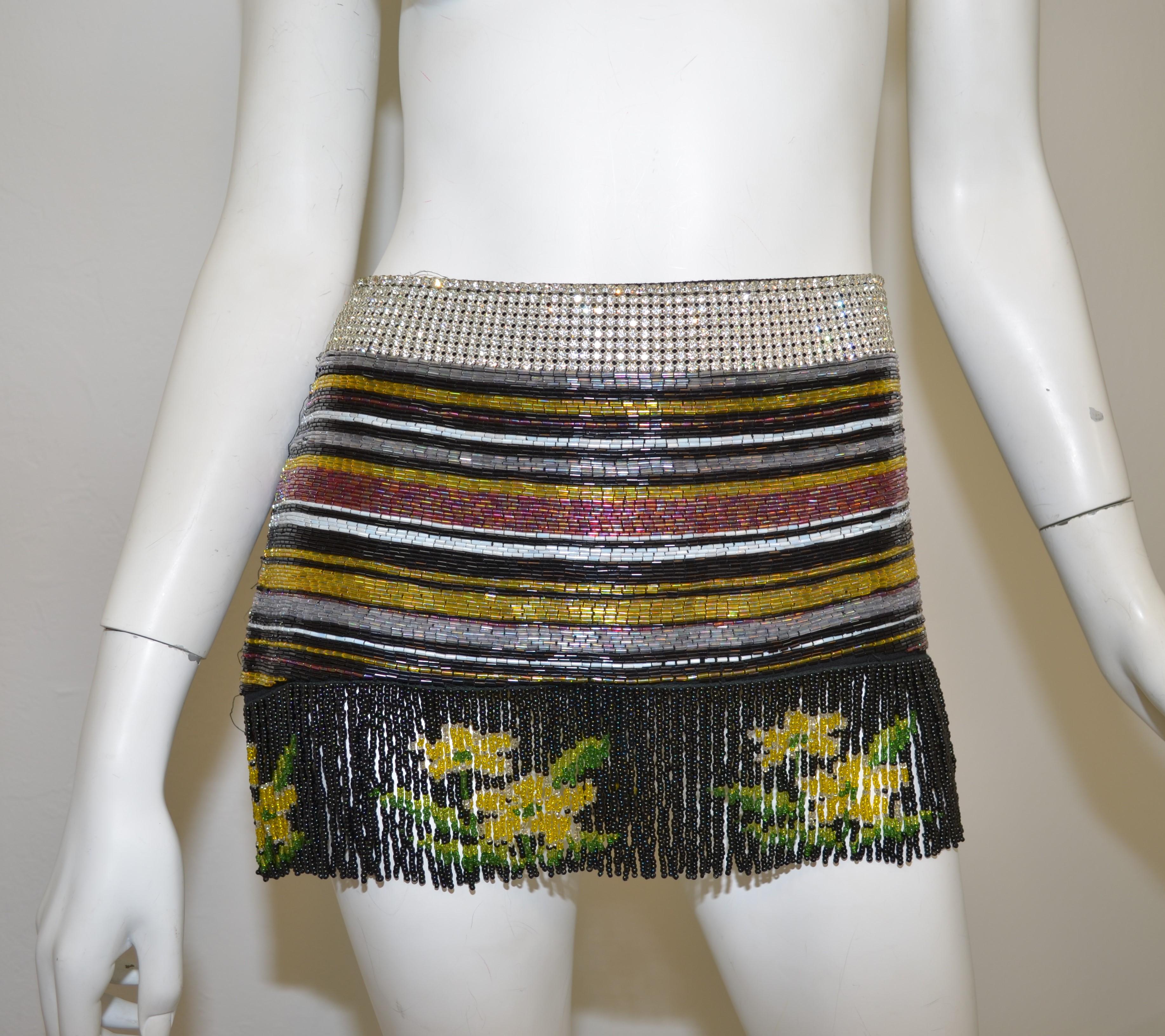 Dolce & Gabbana skirt from Spring/Summer 2000 collection. Multicolor and fully beaded with a fringed hem, rhinestone waist band with a side zipper closure, size 42, and fully lined. Made in Italy.

Measurements:
Waist 33”, hips 38”, length 12”
