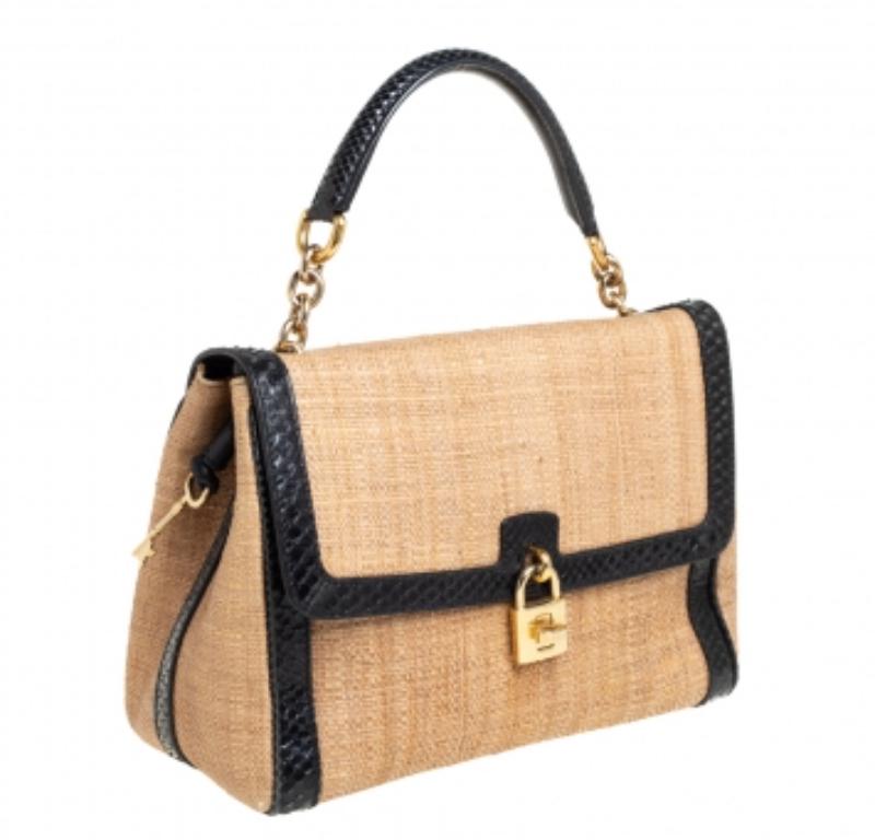 Well-structured and high on style, this Miss Dolce bag from Dolce & Gabbana deserves to be yours! It has been crafted from beige raffia and black python leather trims and styled with a top handle and a detachable shoulder strap. It comes with a