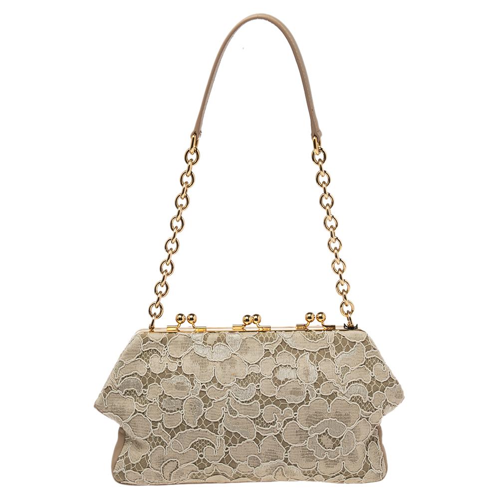 This Frame clutch from Dolce & Gabbana is beautiful in every way. It is created using beige lace fabric and leather on the exterior with a gold-toned logo plaque embellishing the front. This chic clutch makes a great party accessory.

Includes: