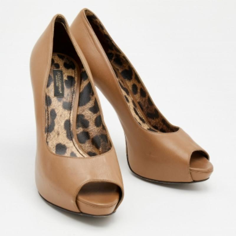 Nunca te equivocarás con estos zapatos de salón beige de Dolce & Gabbana. Fabricados en Italia, están confeccionados en piel de calidad y destilan elegancia. Los zapatos de tacón con plataforma son de estilo peep-toes y tacón de 12 cm. Están