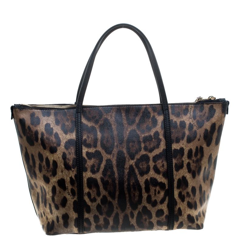 This stunning tote is from the house of Dolce and Gabbana. Crafted from PVC, and lined with fabric on the insides, the bag features a leopard printed exterior with dual top handles and the gold tone logo plaque flaunted on the front. Swing it along