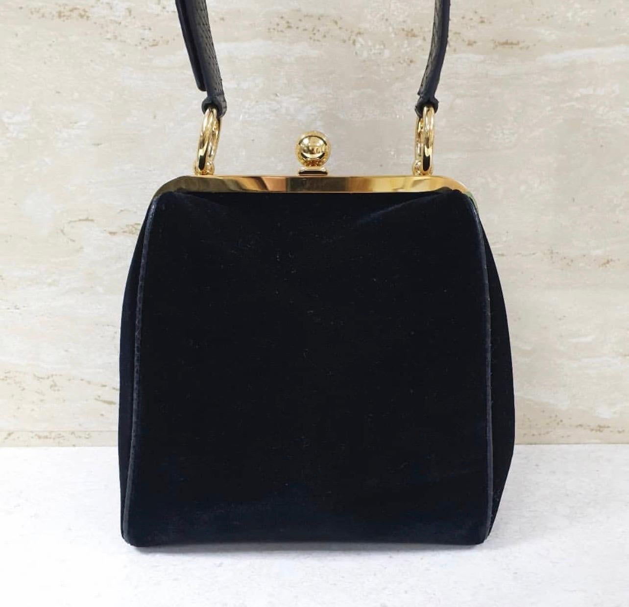 This shoulder bag from Dolce and Gabbana embodies class and sophistication. 
It is crafted with a  black velvet and python exterior and features a framed top with a box-like silhouette and a kiss-lock closure. 
The adjustable shoulder strap allows