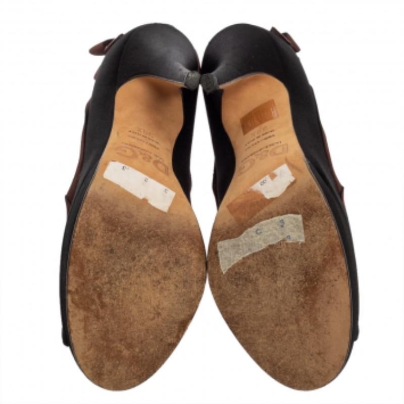 These pumps from Dolce & Gabbana showcase feminine and elegant style. Crafted from satin, they carry lovely shades of black & brown. They are designed with peep toes, bow detailing on the counters, 13 cm heels, and durable leather soles.