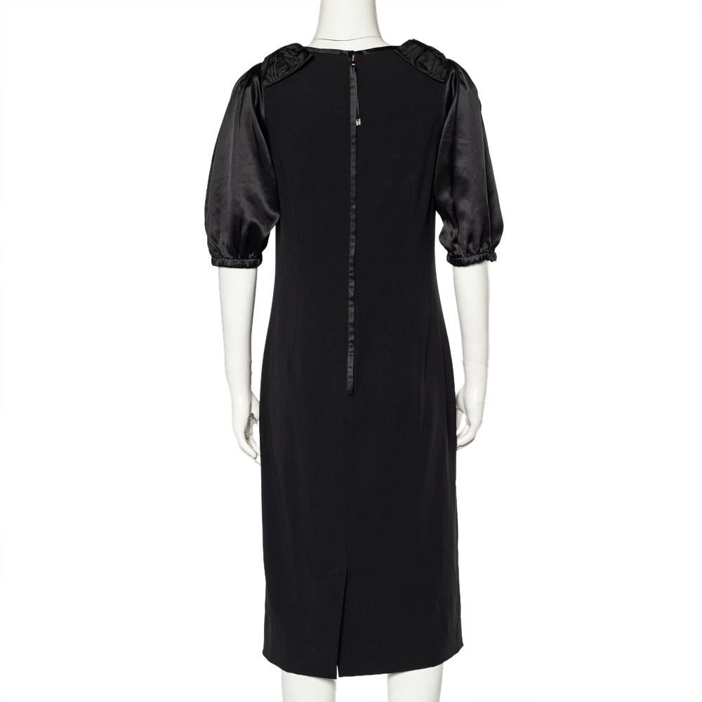This Dolce & Gabbana dress will offer a refined look when paired with the right kind of accessories. The black sheath dress has contrasting sleeves, bow detailing, and a back zipper.

