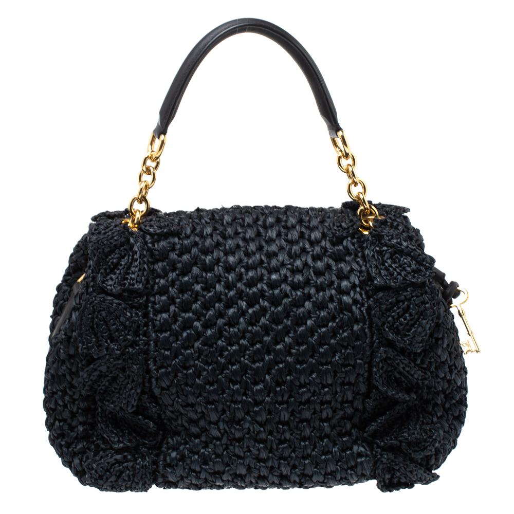 This Dolce & Gabbana handbag is a must-have for the fashion-conscious. Embrace your natural style with this alluring handbag. Crafted from crochet straw and leather, it has a lovely black hue. It has a playful silhouette and features feminine