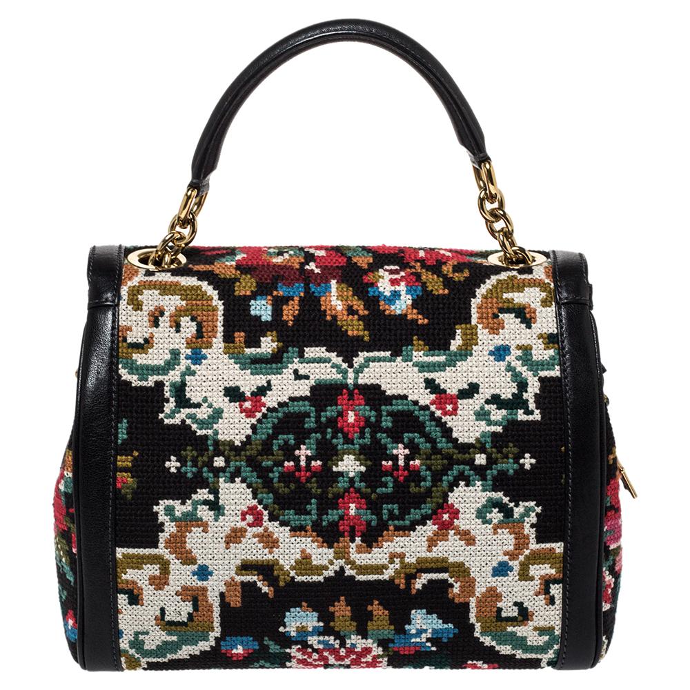 This shoulder bag from the house of Dolce & Gabbana is stylish and functional in equal measures. It is designed in a black fabric & leather body finished with cross-stitch detailing. The flap style is secured with a gold-tone padlock closure. It