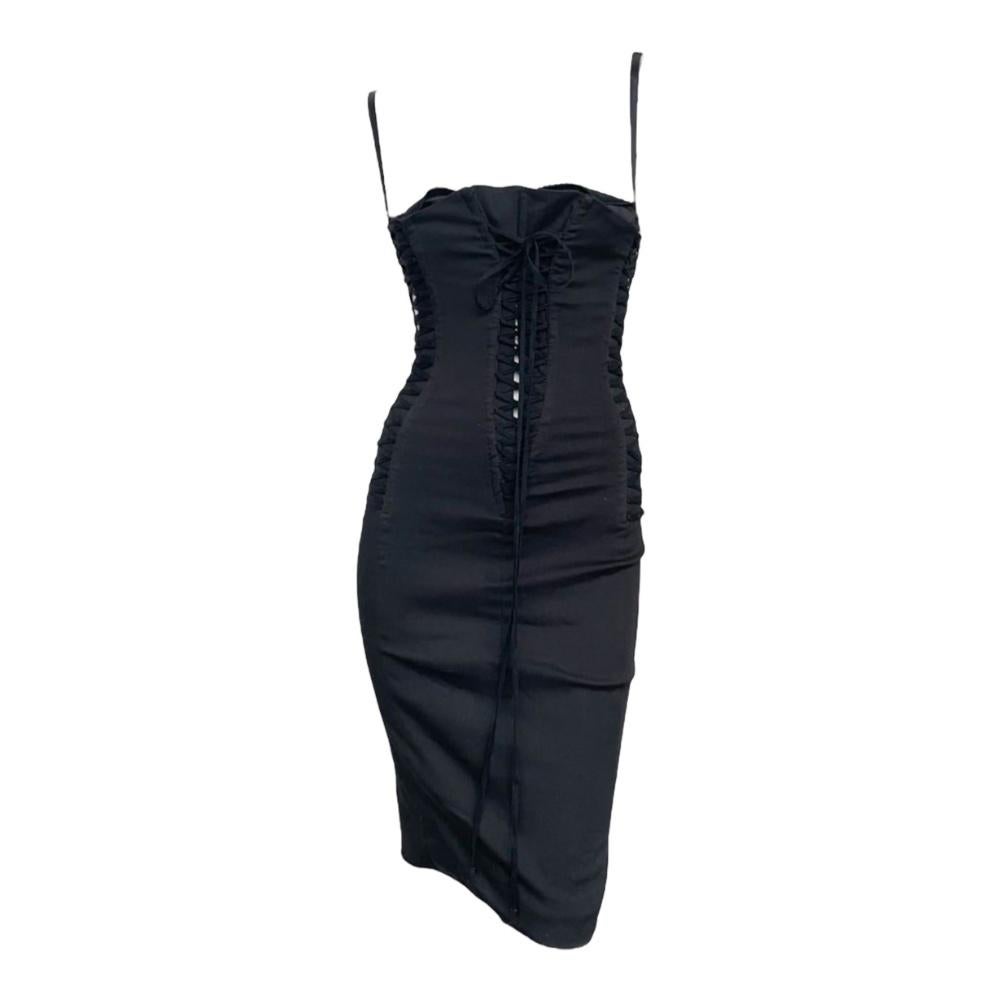 This stunning Dolce & Gabbana  dress from the 2003 collection perfectly embodies the brand’s bold and sensual aesthetic. 
Crafted from luxurious black fabric, the dress features a structured corset bodice that cinches the waist, creating a