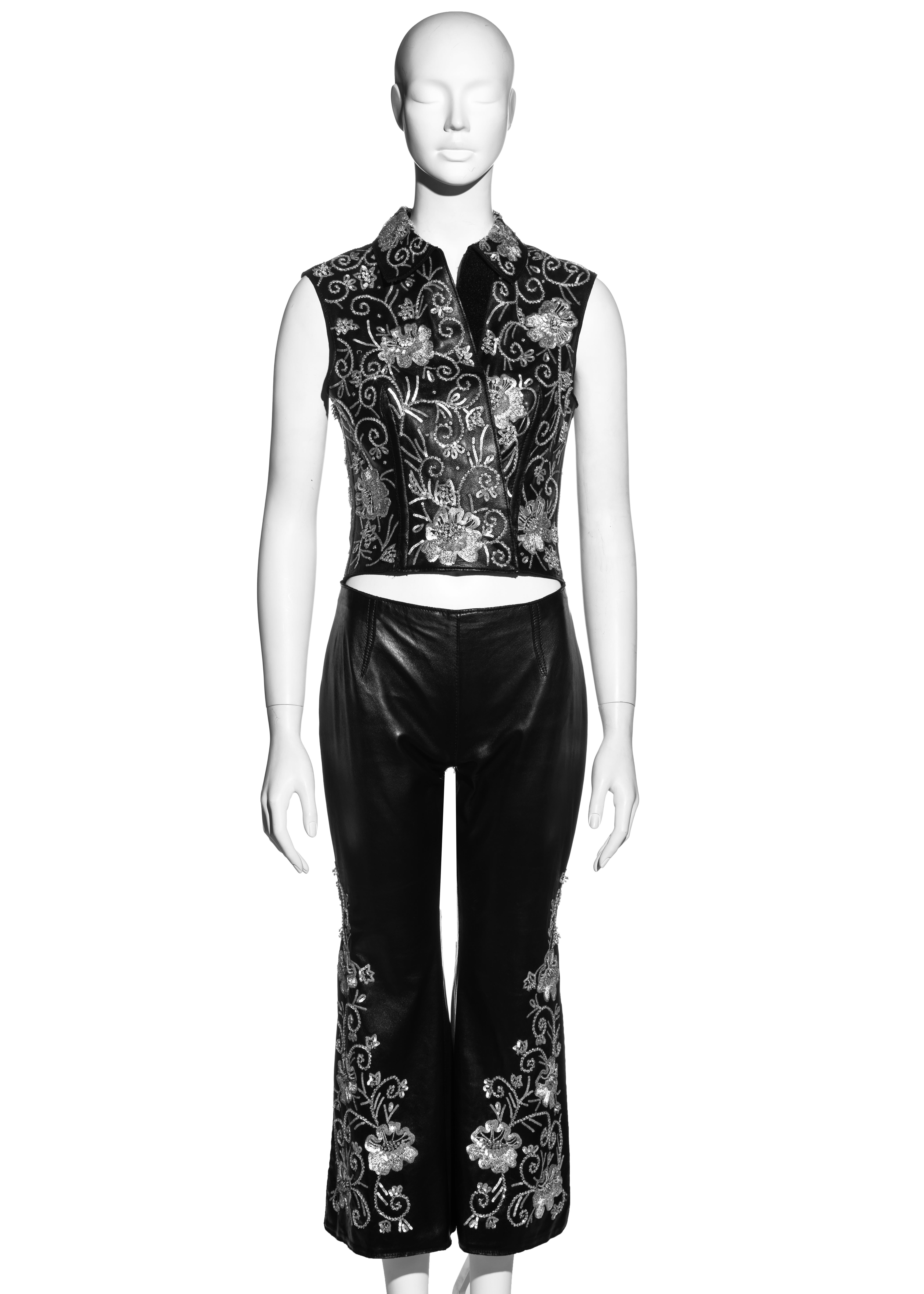 ▪ Dolce & Gabbana black leather pant suit 
▪ 100% Leather
▪ Floral themed silver embellishment and embroidery 
▪ Front velcro fastening on vest 
▪ Leg slits on pants 
▪ IT 40 - FR 36 - UK 8 - US 4
▪ Fall-Winter 1999