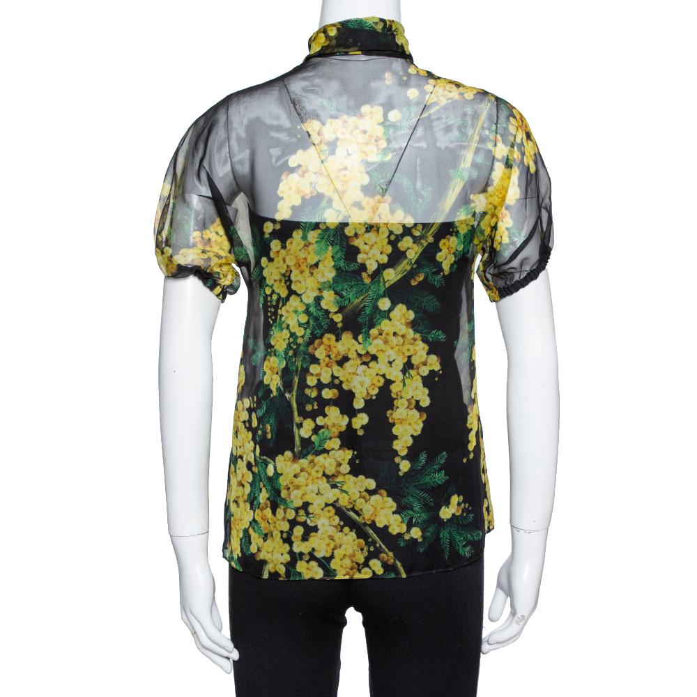 This lovely Dolce & Gabbana blouse is perfect for an impromptu gathering. Crafted from pure silk, it carries a lovely shade of black and the exterior is adorned with a floral print. It has short sleeves, tie-detailing, button front and a flattering