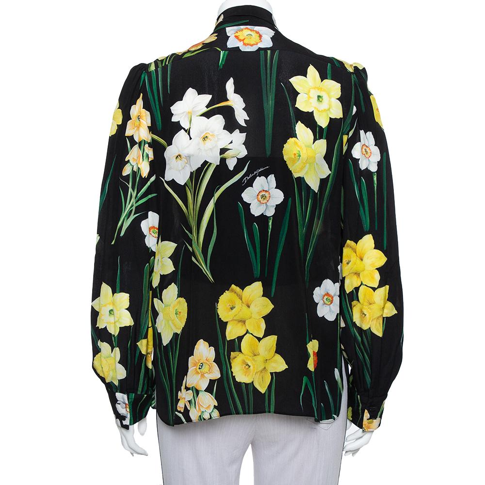 Comfortable and chic, Dolce & Gabbana's top made from silk has a signature appeal that's truly D&G! Tailored beautifully, the top has long sleeves, neck tie detailing, and vibrant flowers laid on the black base. Team it with high-waist pants or