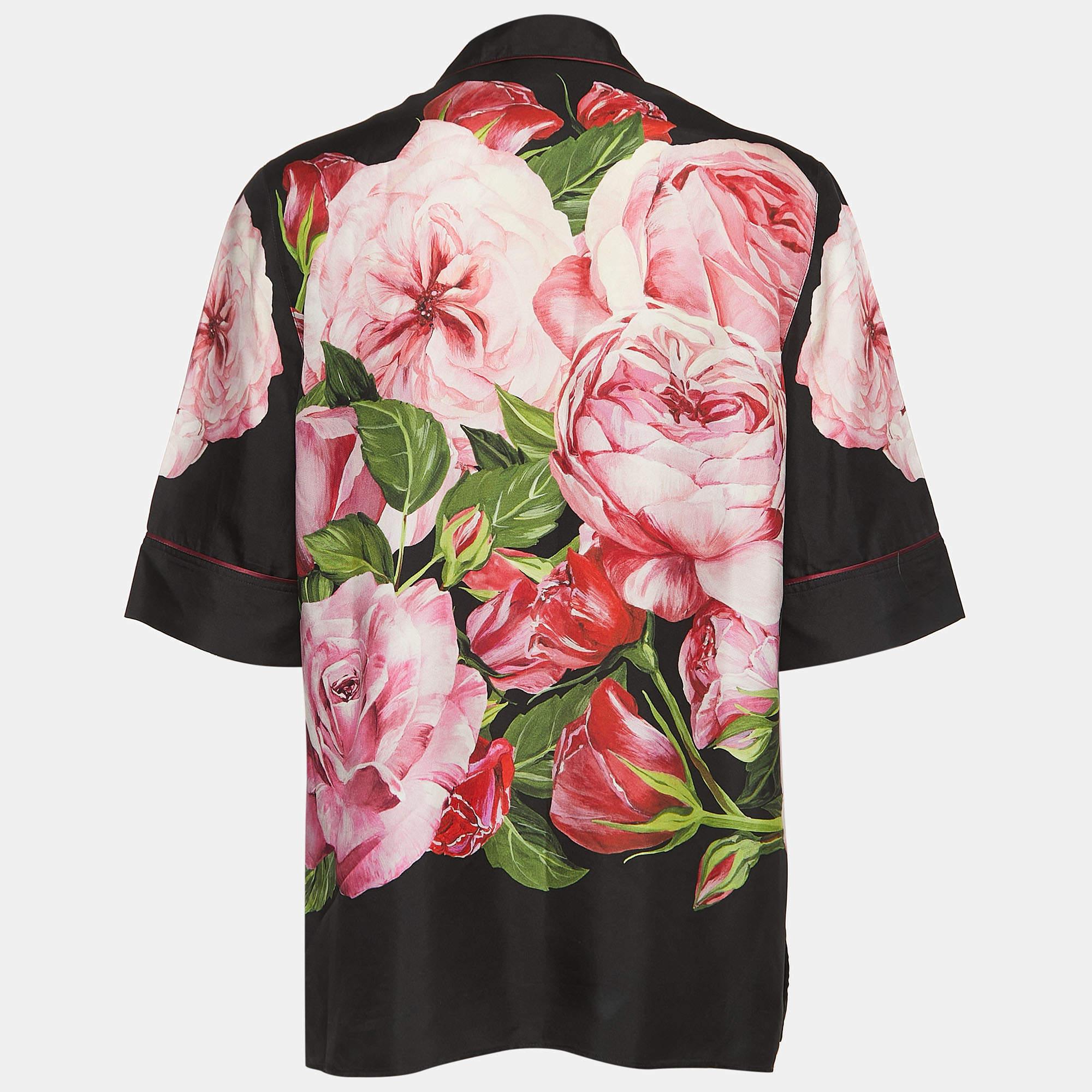 Das Pyjama-Top von Dolce & Gabbana strahlt mit seinem üppigen Seidenstoff und dem aufwendigen Blumenmuster Luxus aus. Der schwarze Sockel hebt die leuchtenden Blüten hervor und sorgt für eine raffinierte und zugleich verspielte Ästhetik. Perfekt zum