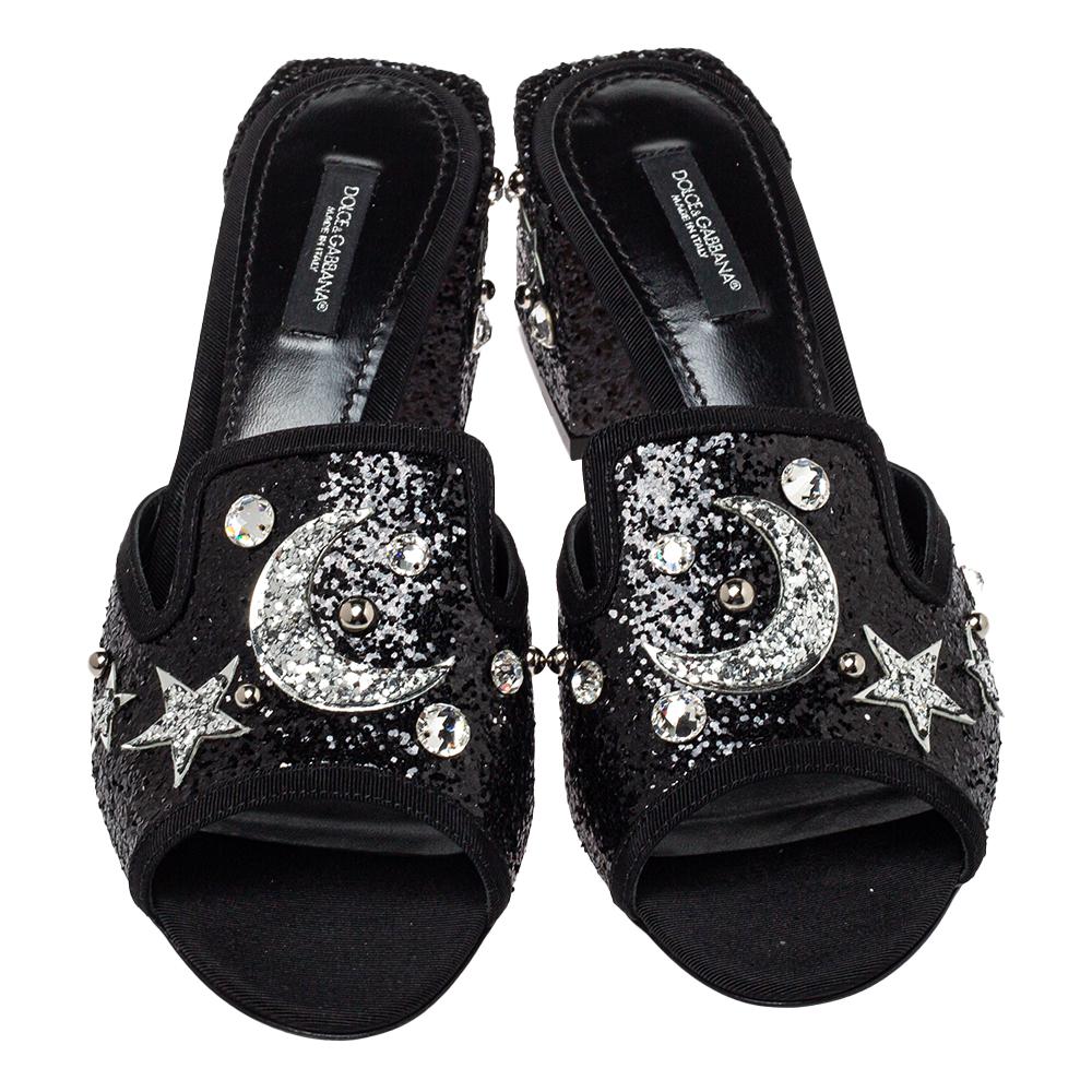 Dolce & Gabbana's feminine flair comes alive in these exquisite Bianca sandals. They are covered with glitter and given a celestial touch with the embellished moon and star motifs all over. These open-toed sandals are elevated on block heels for a