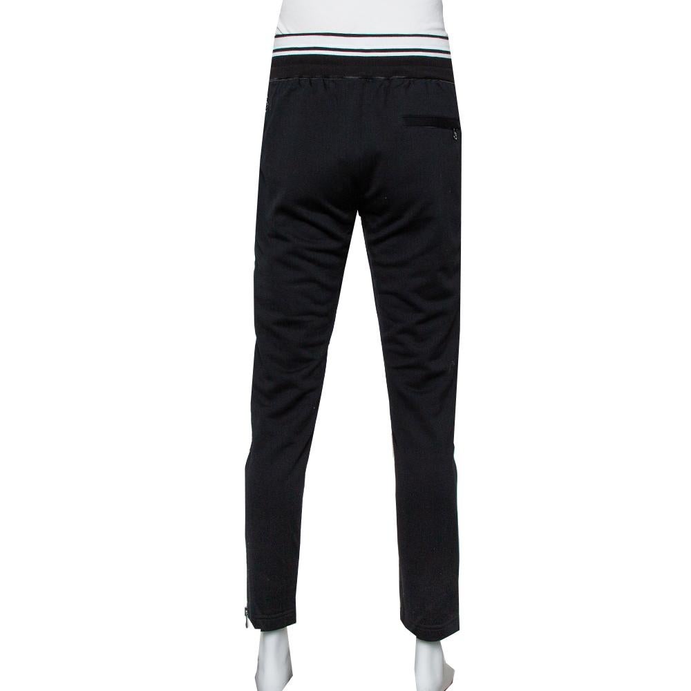 Whether it's lounging around or a casual outing, make sure you look stylish at all times with these Dolce & Gabbana track pants. Made from a blend of cotton, it features stripes and a black shade. The creation is finished off with external