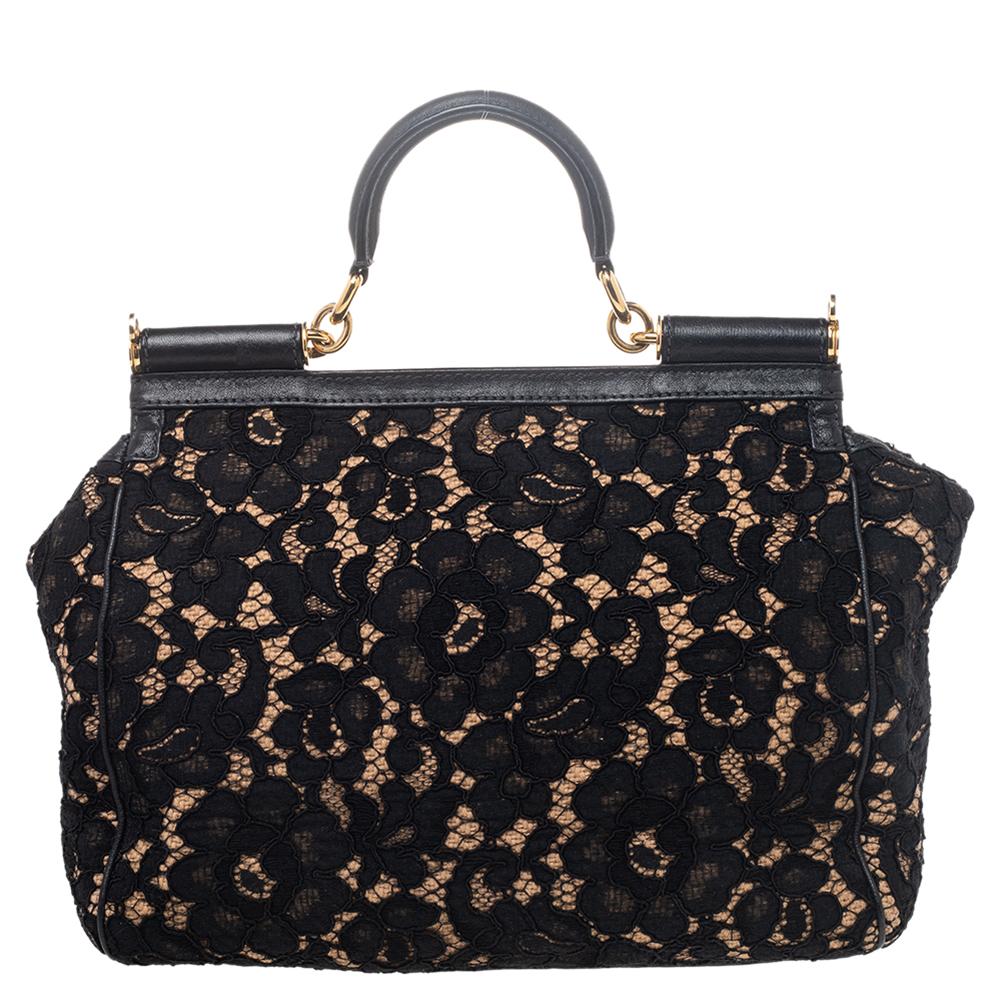 Sling on this feminine and exquisite Dolce & Gabbana lace bag it will match most of your ensembles. This creation features black floral lace with leather underlay and polished gold-tone hardware. It comes with one rolled leather handle and magnetic