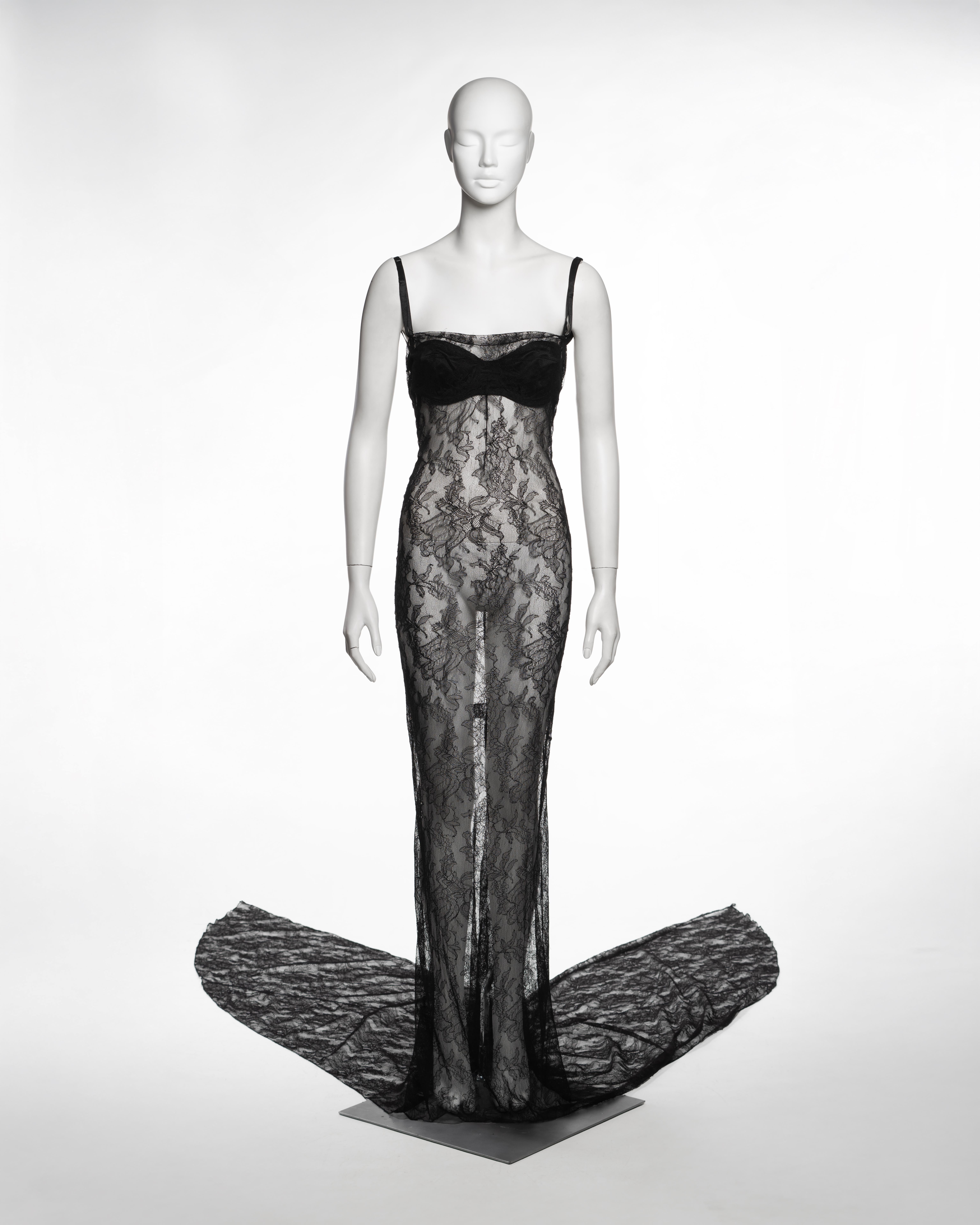 Evening dress by Dolce & Gabbana from the Spring-Summer 1999 collection, composed of a single layer of sheer black lace cut in a floor-length slip silhouette with a trained hem. The lace features a scrolling floral and foliate motif, machine-made in