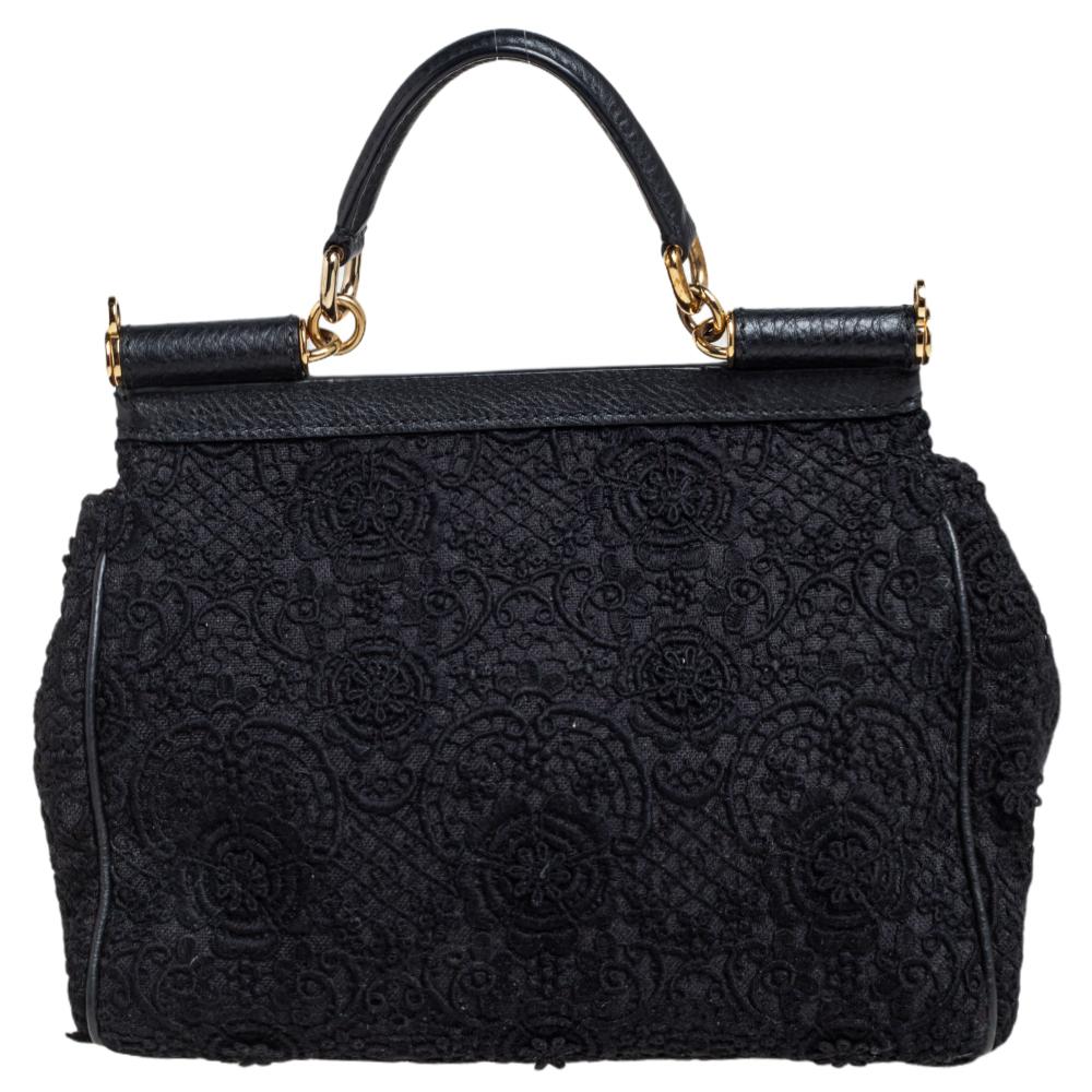 This gorgeous black lace Miss Sicily bag from Dolce & Gabbana is a handbag coveted by women around the world. It has a well-structured design and a flap that opens to a compartment with fabric lining and enough space to fit your essentials. The bag