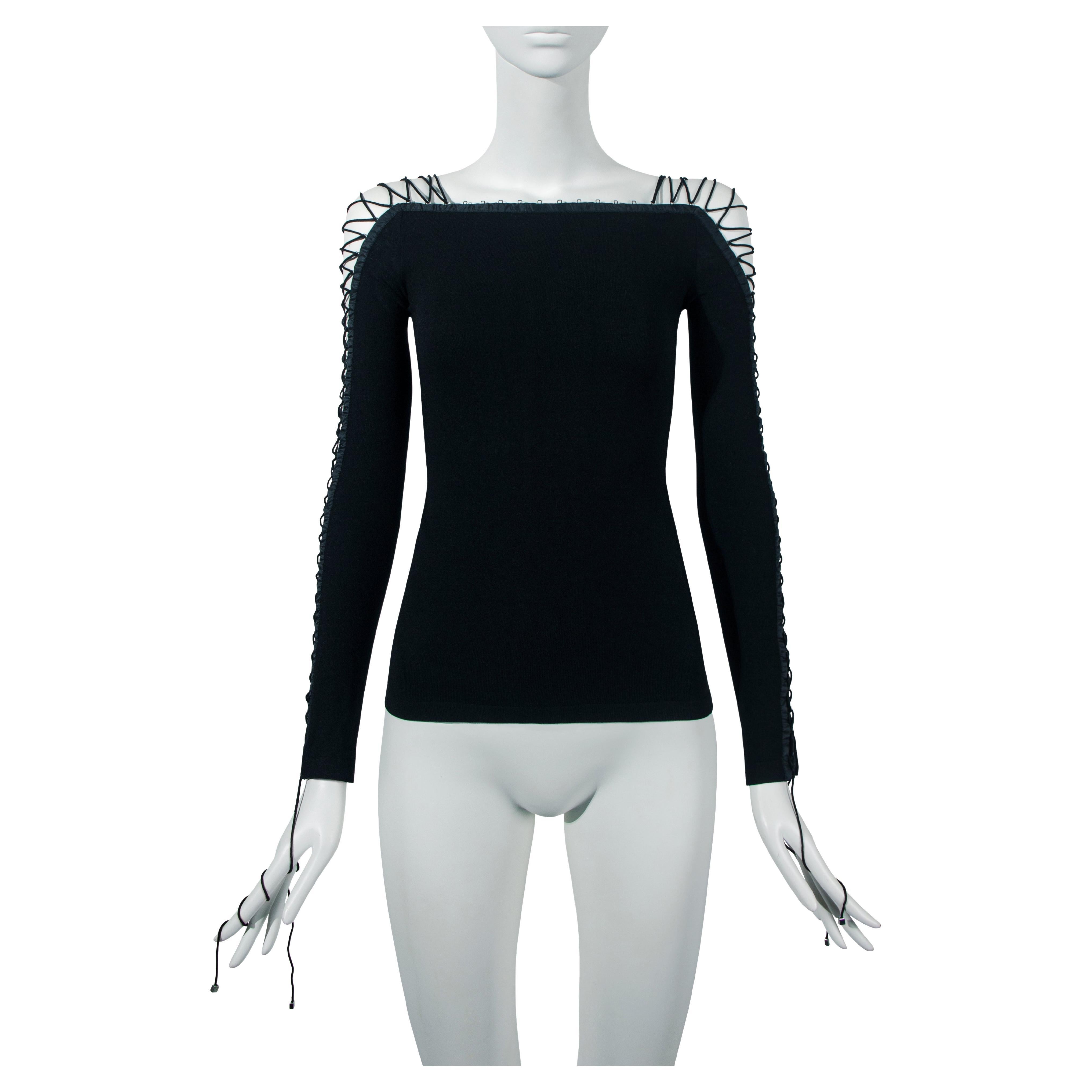 A Dolce & Gabbana lace-up long sleeve top, Fall-Winter 2003. This garment subverts edgy and gothic details to create a stylistic and glamorous garment. Crafted from the finest matte wool, its key feature is the black cord lacing that adorns both the