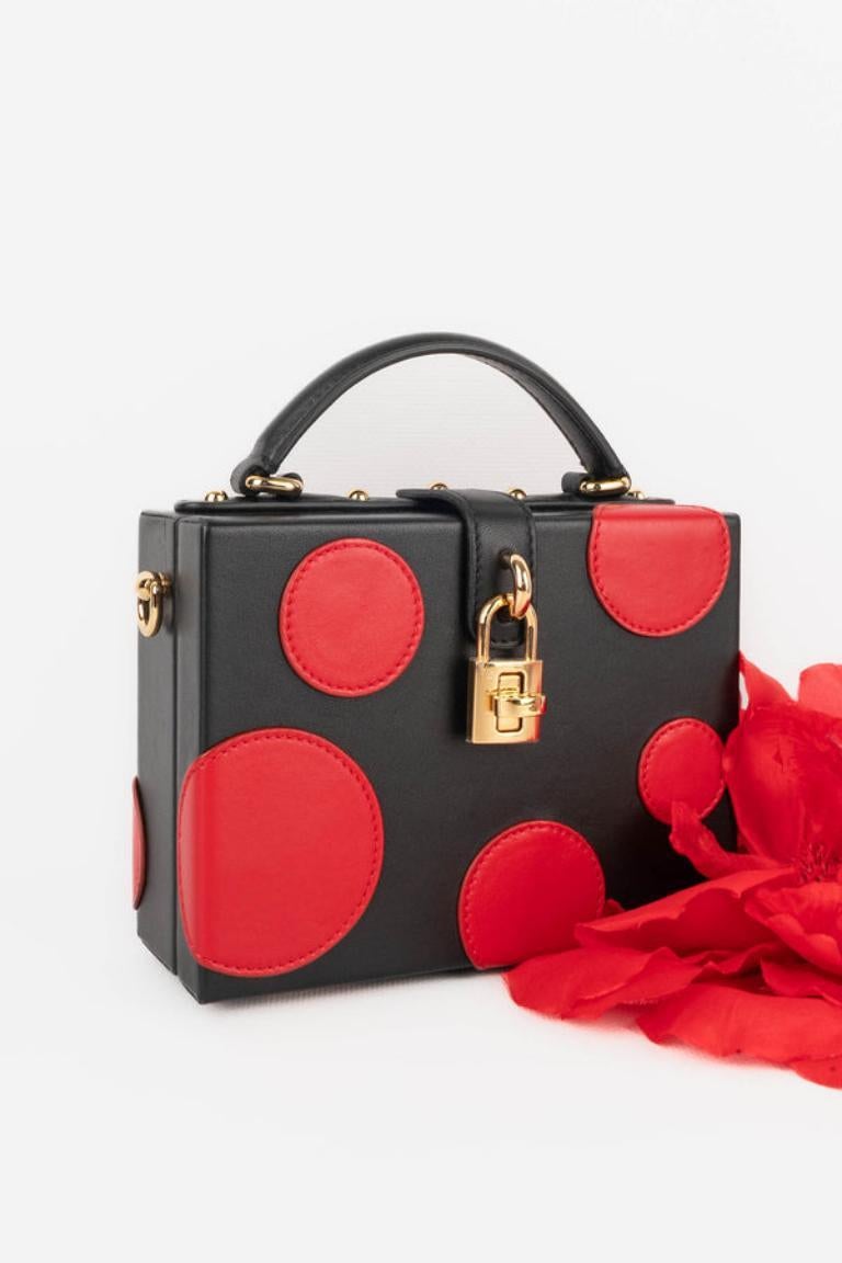 Dolce & Gabbana - (Made in Italy) Tiny black lamb  leather briefcase bag with red lamb leather circles and golden metal elements.

Additional information: 
Condition: Very good condition
Dimensions: Length: 16 cm - Height: 12 cm - Depth: 6 cm -