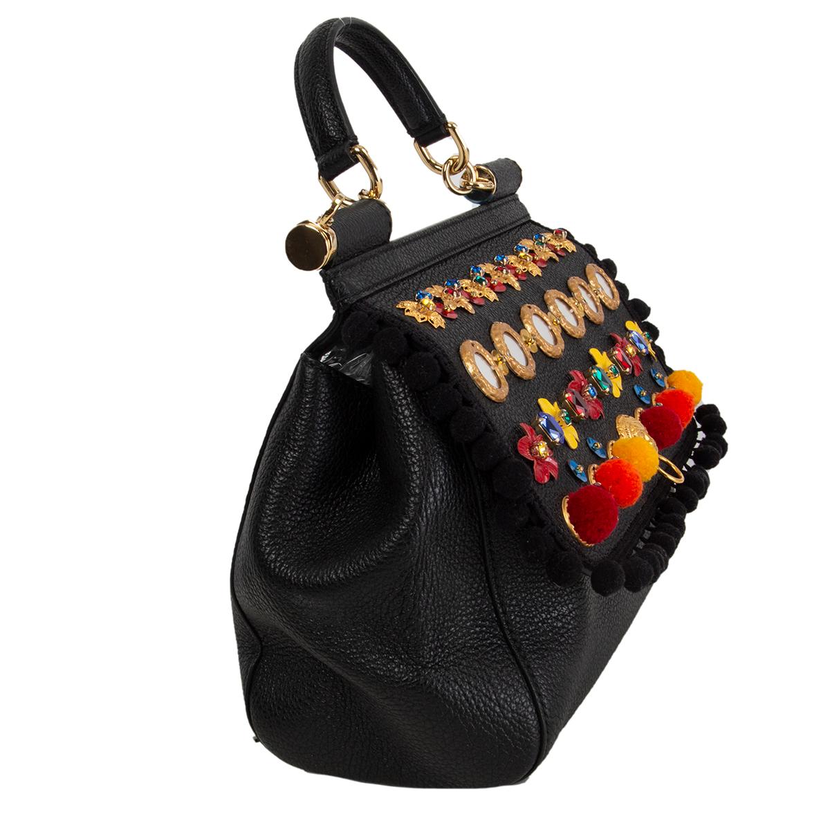 Dolce & Gabbana 'Medium Sicily' shoulder bag in black grained calfskin featuring emblems, crystals, flowers, majolica ceramic, lion head and pom-pom embellishments arounf the trim. Opens with with two magnetic buttons under the flap and ins lined in