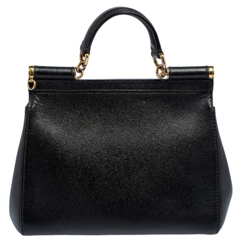 The iconic Miss Sicily bag by Dolce & Gabbana is named after Domenico Dolce's native land and exhibits the aesthetic of Italian glamour. The neat silhouette is made from leather and features a front flap. The creation is complemented with gold-tone