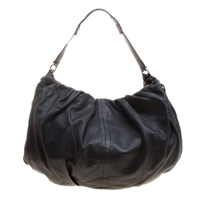 Diese Dolce and Gabbana Miss Night and Day Hobo ist perfekt, um alles zu verstauen, was Sie für den Tag brauchen. Sie ist ein Muss für jeden Tag. Die aus schwarzem Leder gefertigte Tasche verfügt über plissierte Details auf der Oberfläche sowie