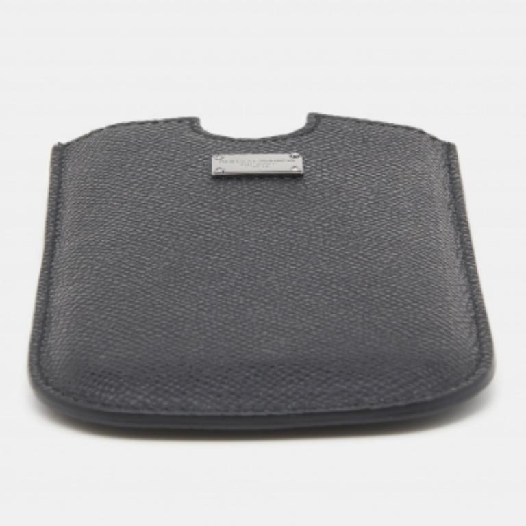 Proteggi il tuo smartphone con questa custodia della Maison Dolce & Gabbana. Questa custodia è realizzata in pelle nera e foderata in pelle all'interno. Una targa argentata è appesa al font. Questa elegante custodia sta aspettando di essere tua!