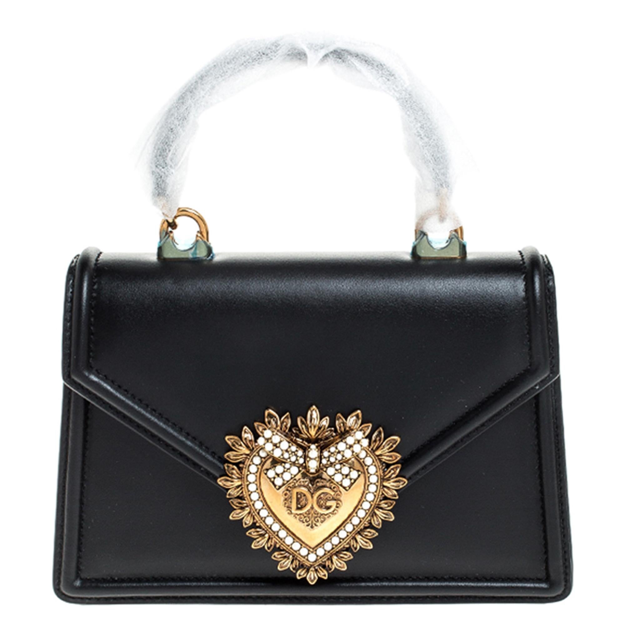 Step out in style by adorning this bag from Dolce & Gabbana. It has been crafted from leather and flaunts the Devotion heart motif in gold-tone on the front. It features well-designed leather-lined interior housing a slip pocket. The bag is complete