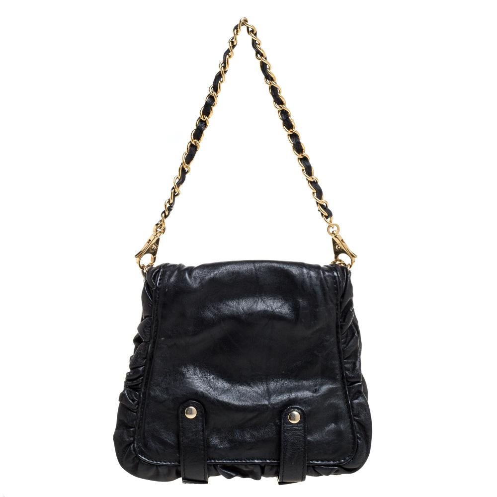 This stunner hails from the house of Dolce & Gabbana! It was created to celebrate the iconic brand's XX Anniversary. It has been crafted from leather and carries a black hue. The clutch has been styled with ruffles, gold-tone hardware, buckles, a
