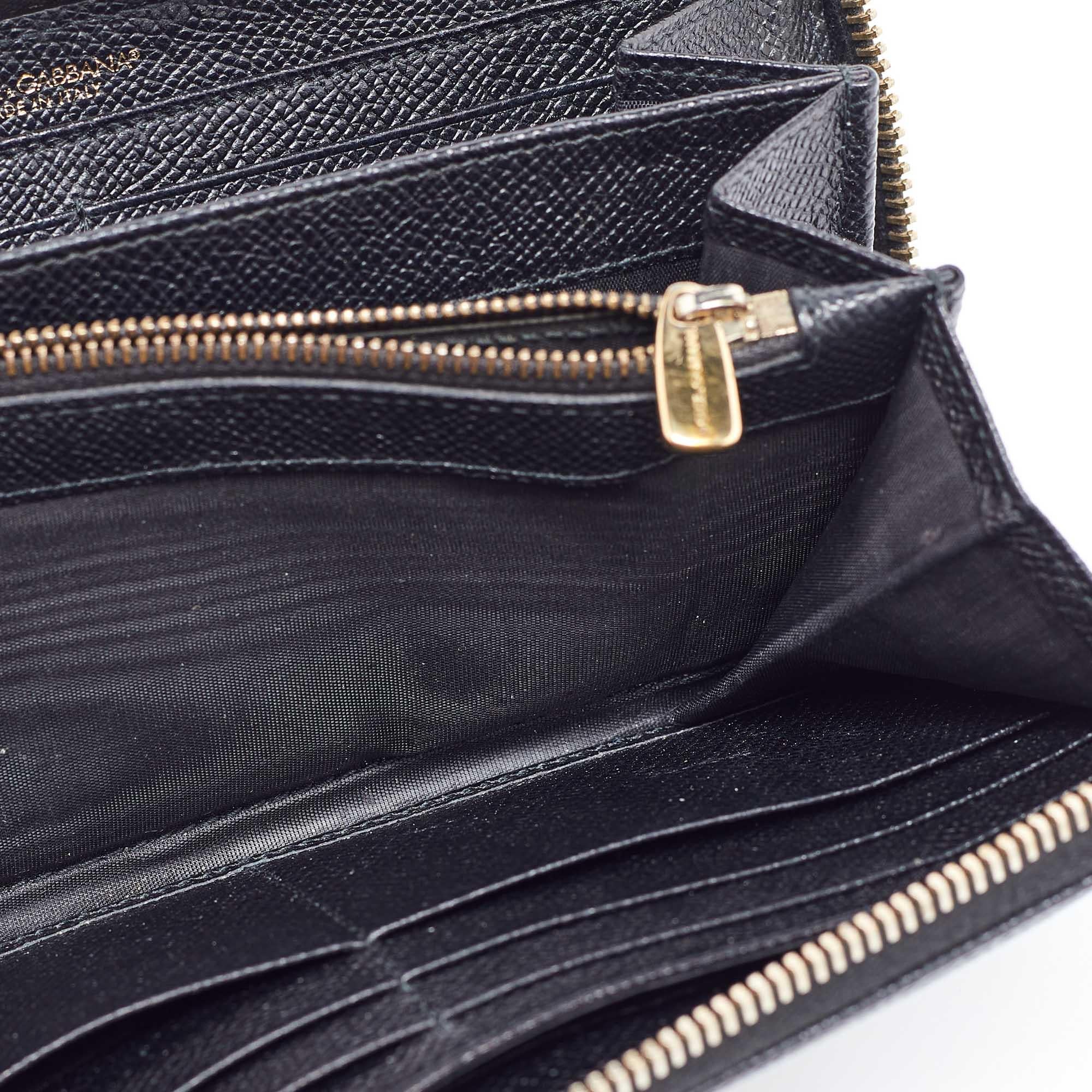 From Dolce and Gabbana here is a creation you will love to own This wallet is designed luxuriously to offer practicality and style. It is made from black leather with a gold toned logo plaque embellishing the front. The zip around feature opens to a