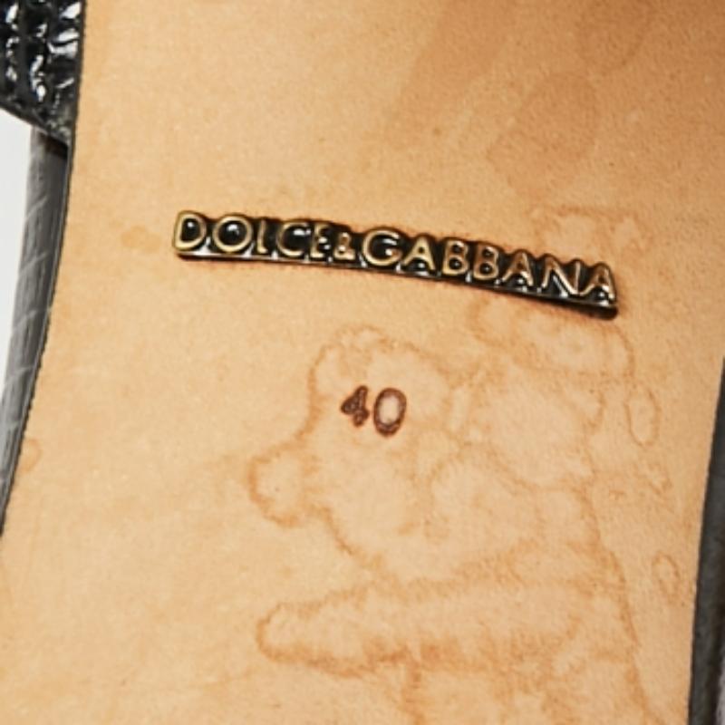 Cette paire de sandales Dolce & Gabbana est d'une grande sophistication. Les chaussures sont fabriquées en cuir embossé de lézard et ont des bouts ouverts, une fermeture à la cheville, des éléments décoratifs et des talons de 10 cm.