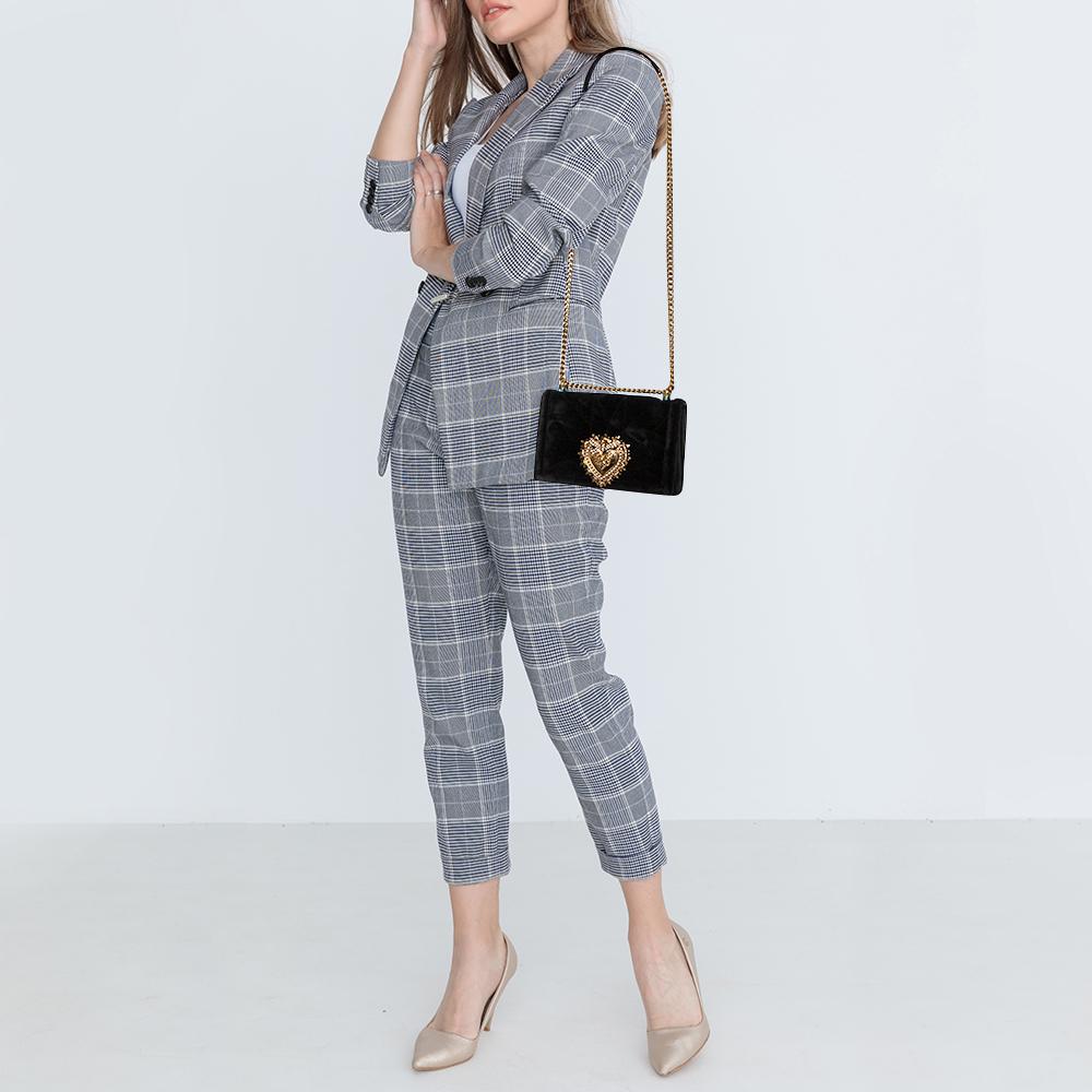 Gehen Sie stilvoll aus mit dieser Umhängetasche von Dolce & Gabbana. Es wurde aus Matelasse-Samt gefertigt und zeigt das Devotion-Herzmotiv in Goldton auf der vorderen Klappe. Die Tasche ist innen mit Leder gefüttert und verfügt über ein Steck- und