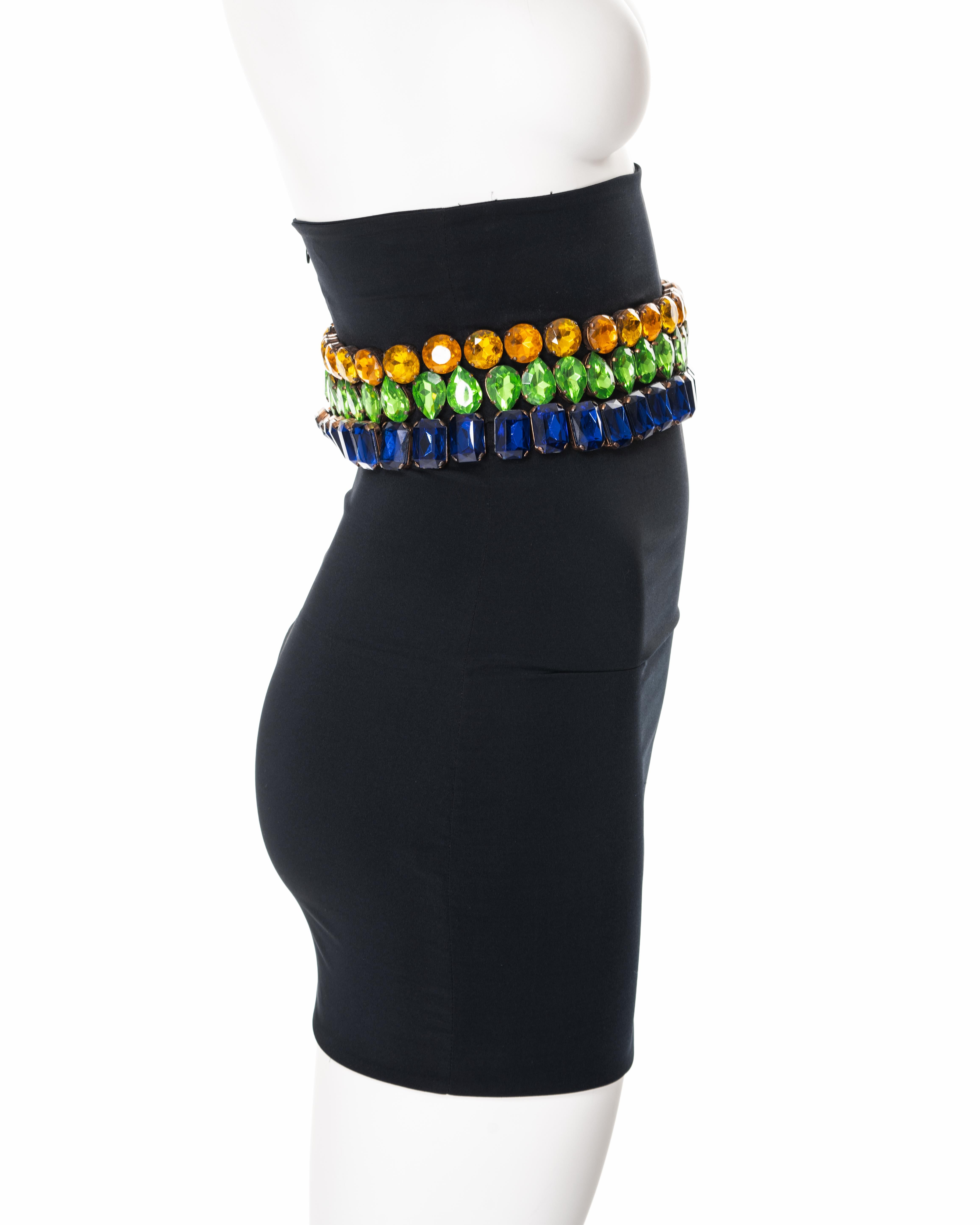▪ Dolce & Gabbana bejewelled mini skirt
▪ Sold by One of a Kind Archive
▪ Fall-Winter 1991
▪ Constructed from a black nylon and lycra blend fabric 
▪ Large crystal adornments in amber, green and blue 
▪ High-waisted 
▪ Figure hugging fit 
▪ Size IT