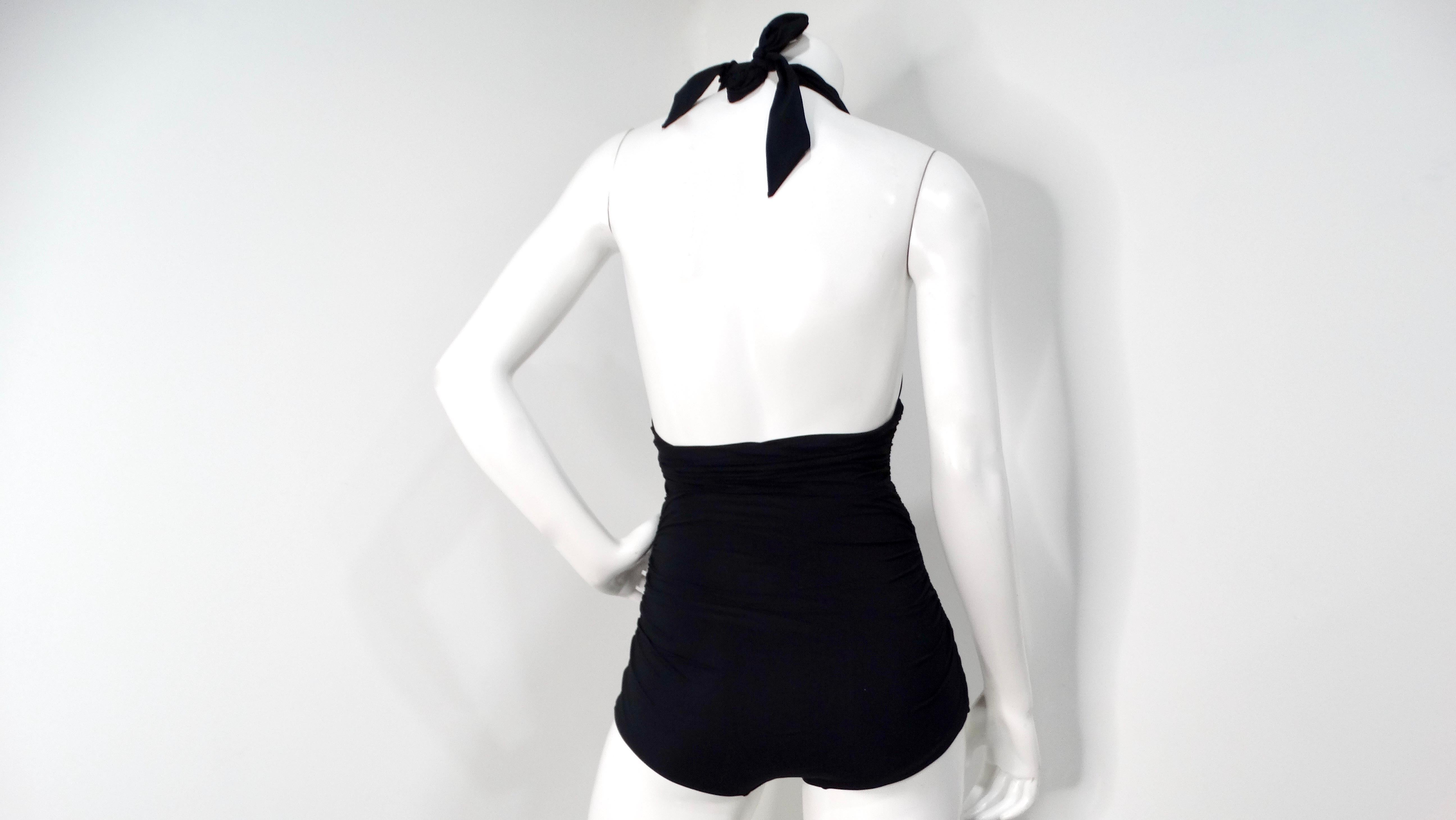 The Dolce & Gabbana Black One-Piece Swimsuit with Plunging Neckline exudes sensual sophistication, making it an essential addition to your swimwear collection. Its striking plunging neckline accentuates the décolletage, while the backless design