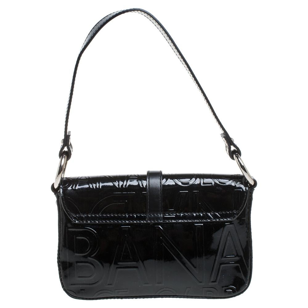 Designed in a pochette silhouette, this bag by Dolce & Gabbana is a marvelous creation with a distinctive structure and unique details. Crafted with patent leather, the exterior of the bag is delicately embossed with the brand label. The front flap
