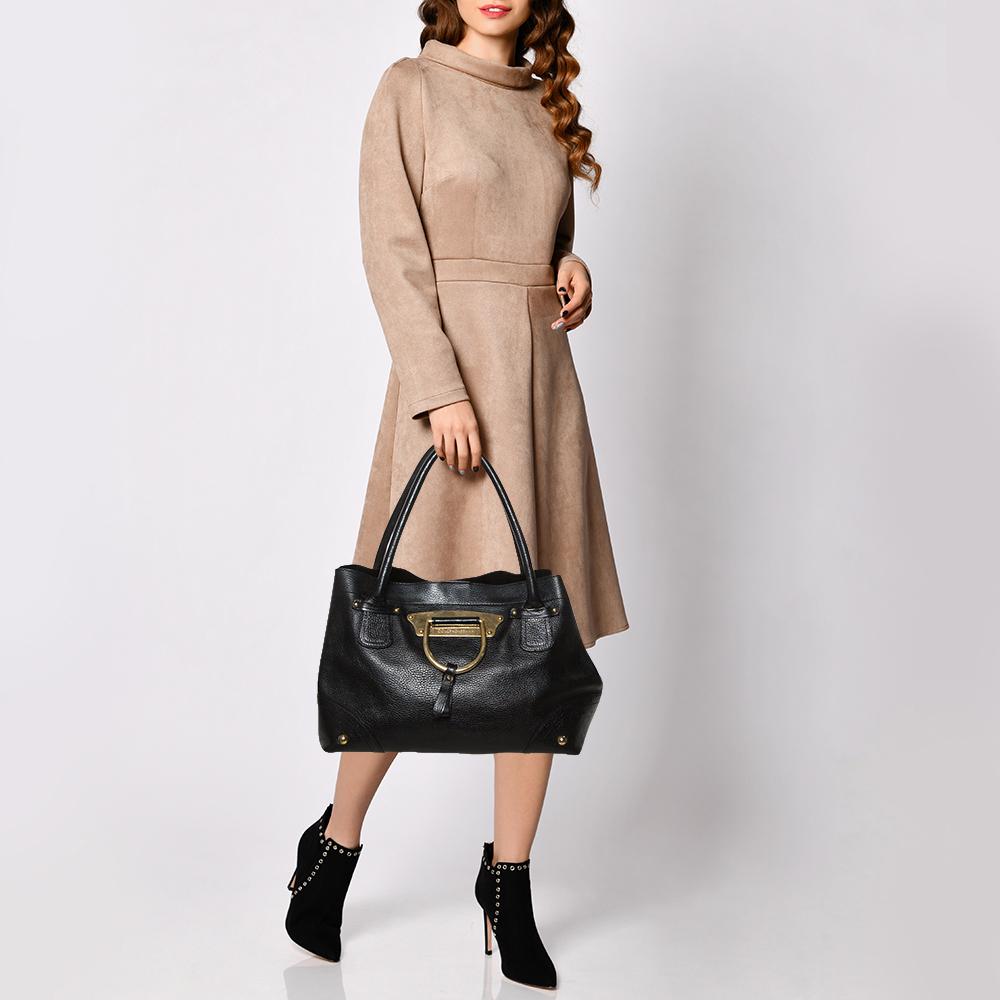 Este espléndido bolso Vintage de Dolce & Gabbana es sencillamente lujoso. Se ha confeccionado en piel granulada negra y se ha realzado con herrajes dorados. Presume de un detalle de anilla en D en la parte delantera y viene equipada con dos asas