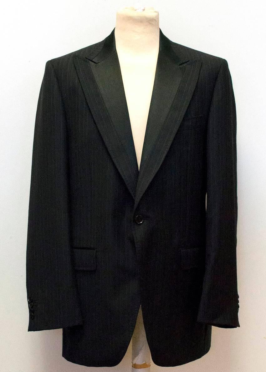 Dolce & Gabbana black wool blazer with light pinstripes. It is single breasted and features a wide silk peak lapel, single vent, three exterior pockets, three interior pockets and black buttons. 

Condition: 9.5/10 
Measurements are taken with the