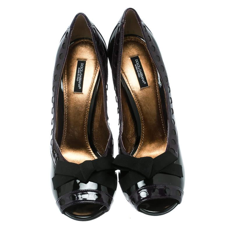 Perfect to compliment any outfit, these black and purple pumps from Dolce and Gabbana are worthy of being a part of your closet! They have been crafted from patent leather and styled with peep-toes. They flaunt a trendy bow detailing on the vamps