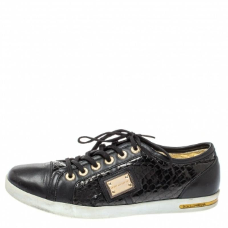 Fall in love with casual wear every time you step out in these low-top sneakers from Dolce & Gabbana. They've been crafted from black python-embossed leather and leather and styled with round toes, laces on the vamps, and gold-tone logo plaques on