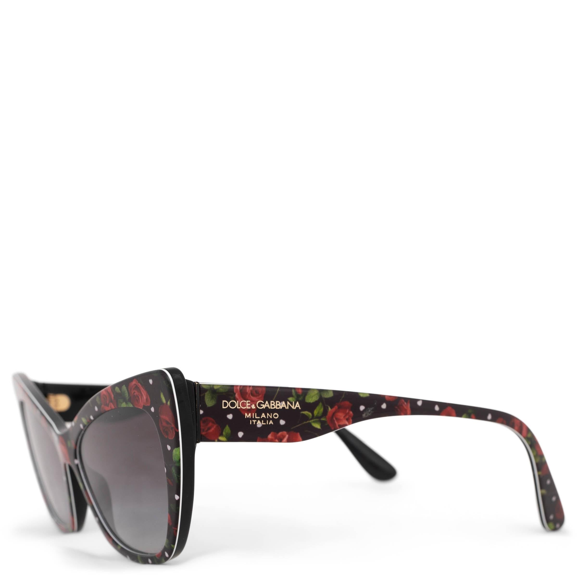 These 100% authentic Dolce & Gabbana Cat Eye Sunglasses feature a bold and stylish design with a black acetate frame adorned with playful white polka dots and vibrant red roses. The classic cat-eye shape offers a chic, retro-inspired look, while the
