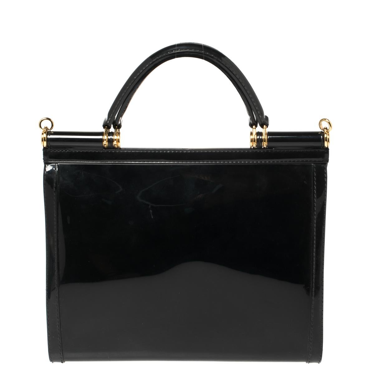 This beautiful black colored Miss Sicily bag from Dolce & Gabbana has a structured design. Crafted from rubber, the bag features a top handle, an adjustable detachable shoulder strap printed with: L'amore È Bellezza, and the brand label at the